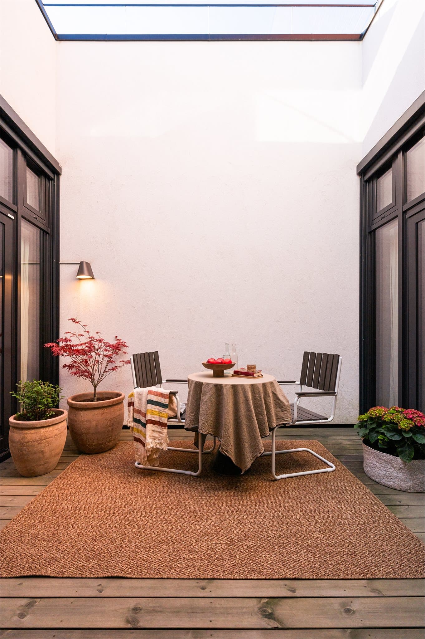 Atriet oppleves som en naturlig forlengelse av oppholdsrommene, og gir en utendørsfølelse samtidig som det skjermer mot innsyn.