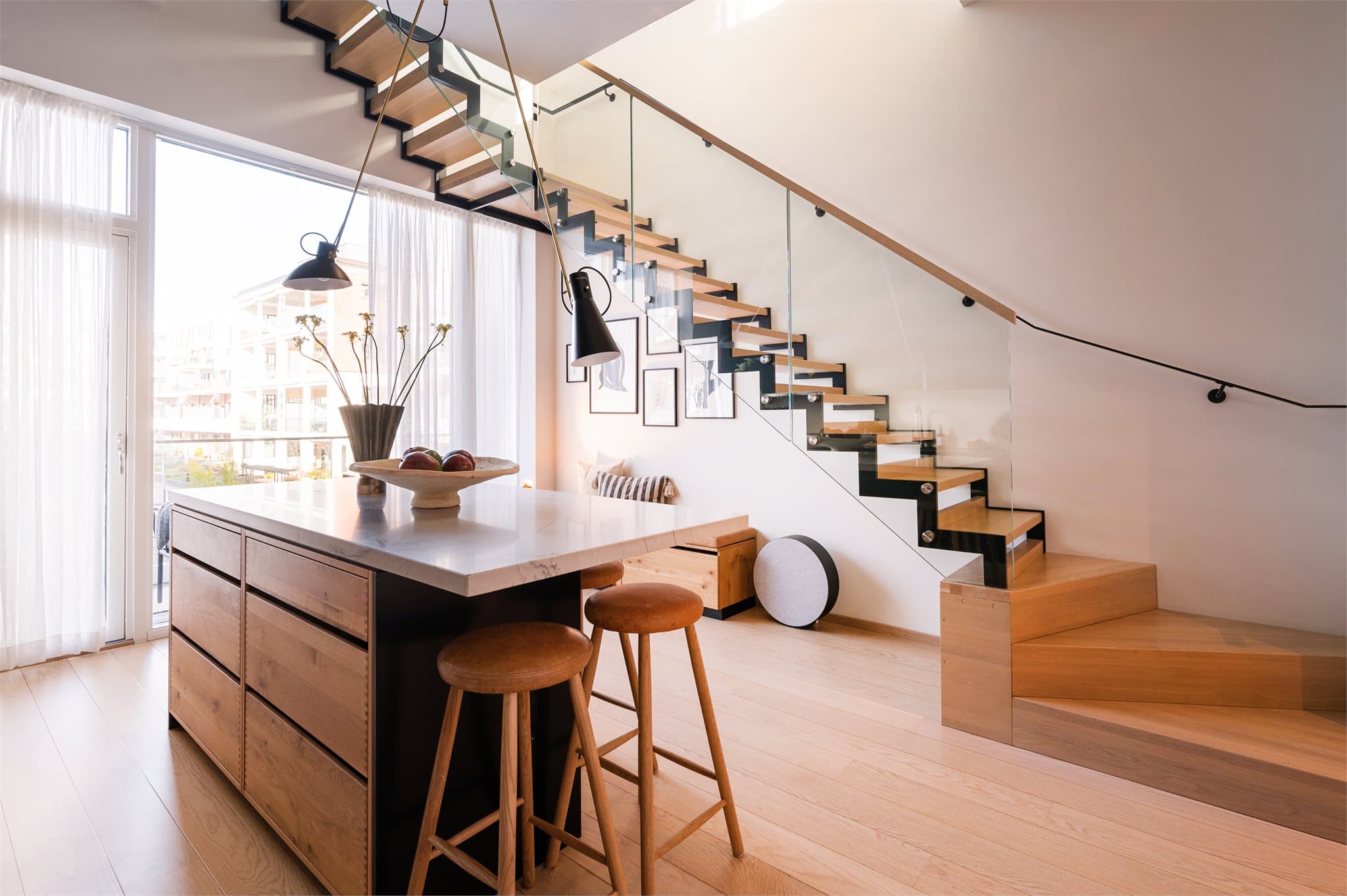 Den lekre kjøkkenøya i rustikk eik med marmorinspirert benkeplate er et naturlig blikkfang i rommet.