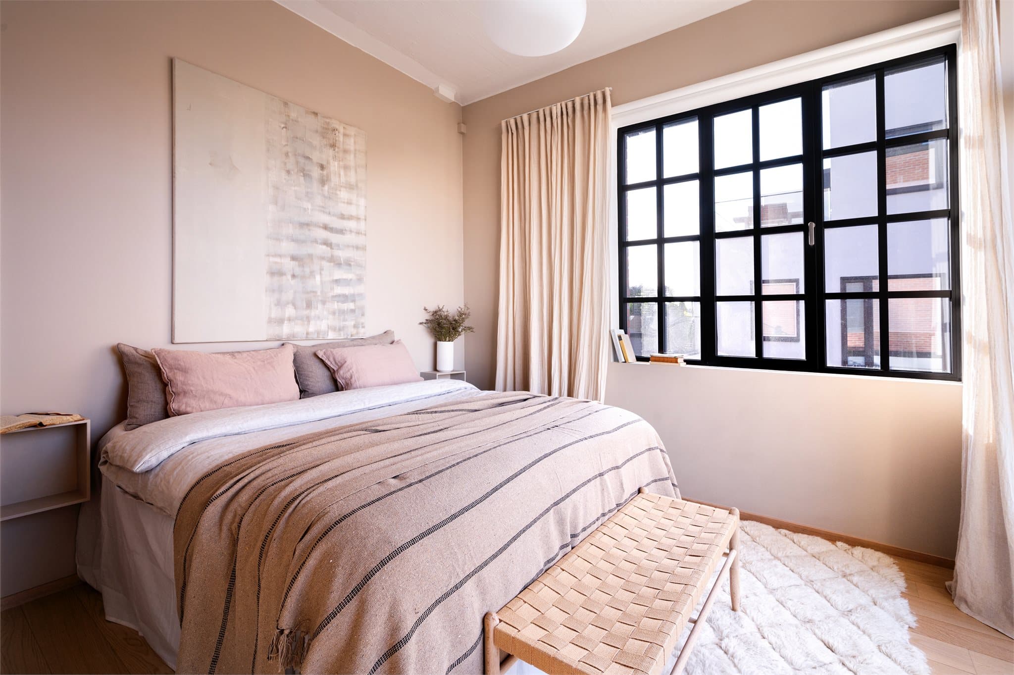 Vinduene er utformet med sorte, smårutete karmer som tilfører et moderne og sofistikert preg.