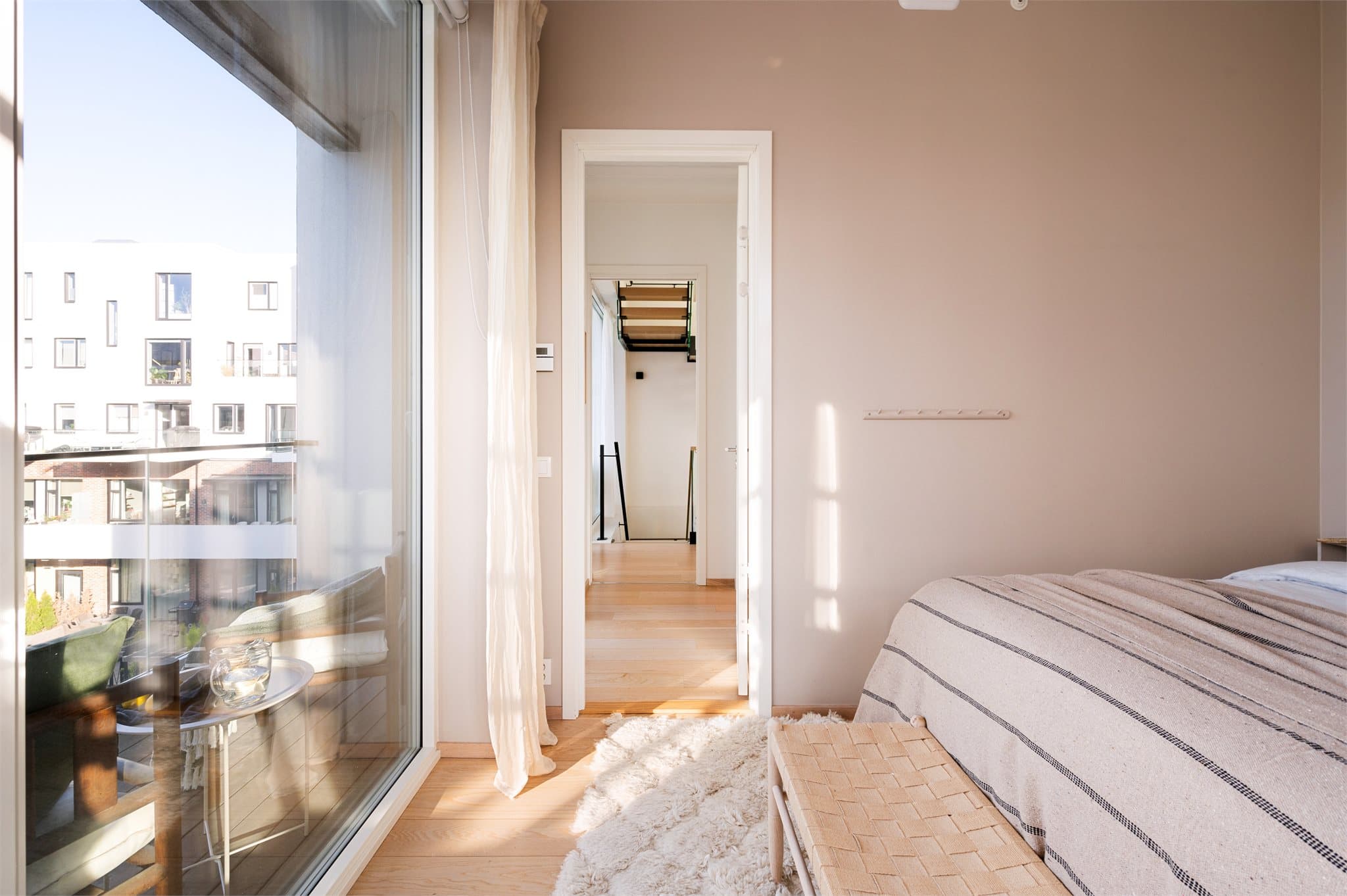 I leilighetens andre etasje ligger et lyst og innbydende soverom som på elegant vis kombinerer komfort og stil.