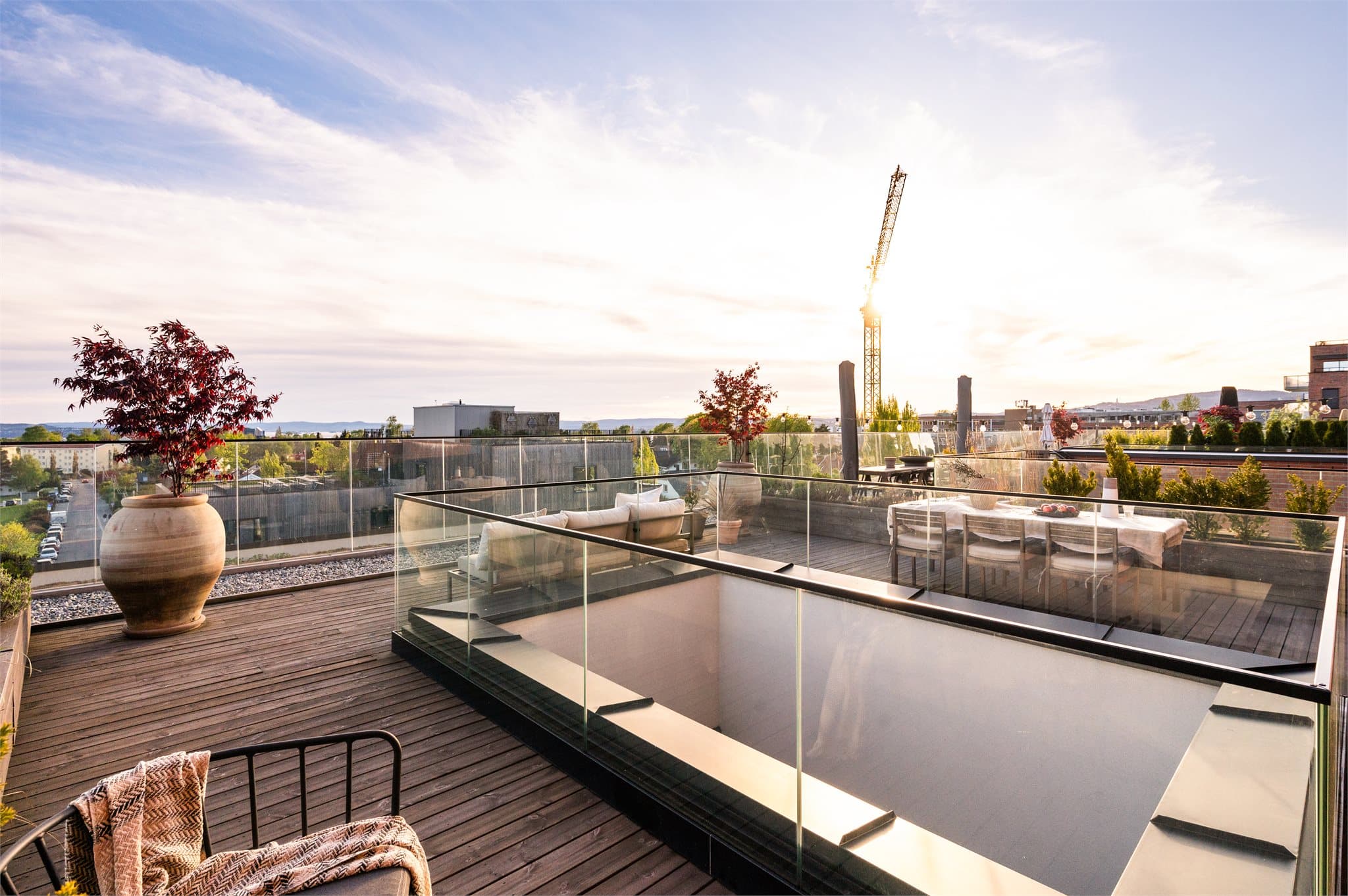 Takterrassen er smakfullt innredet med terrassebord og en plassbygd sofa som kombinerer komfort med et stilrent uttrykk.