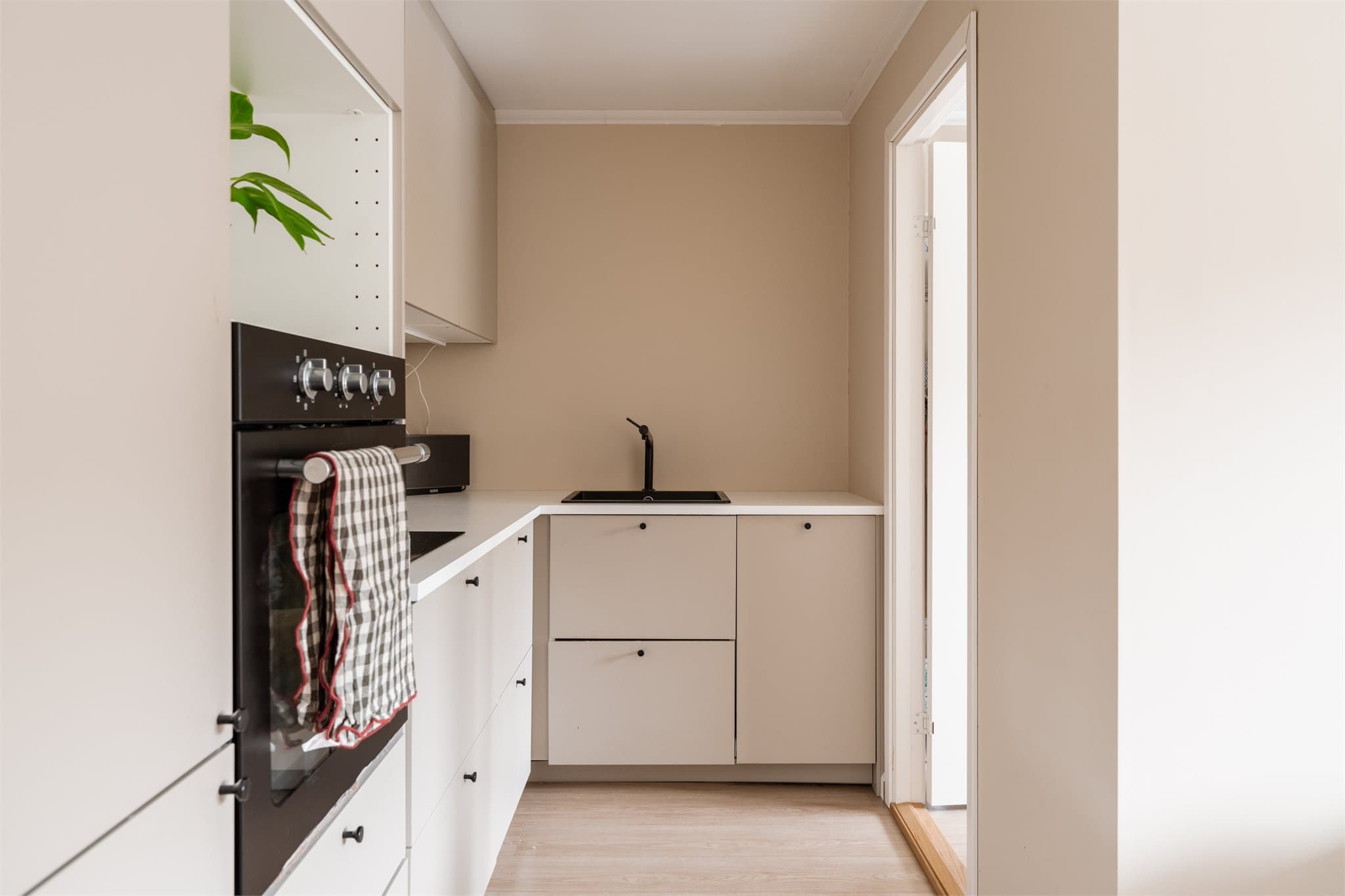 Det ene av leilighetens to kjøkken (2023), moderne utført med glatte fronter og integrert stekeovn.