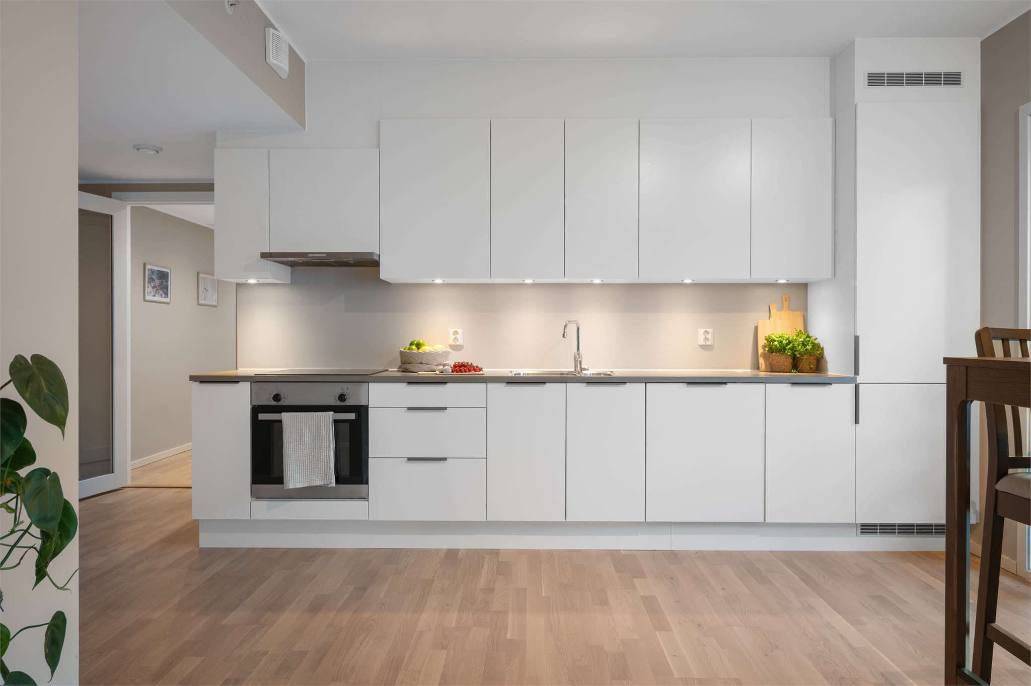 - Lekkert, tidløst kjøkken med slette fronter og benkeplate av laminat -