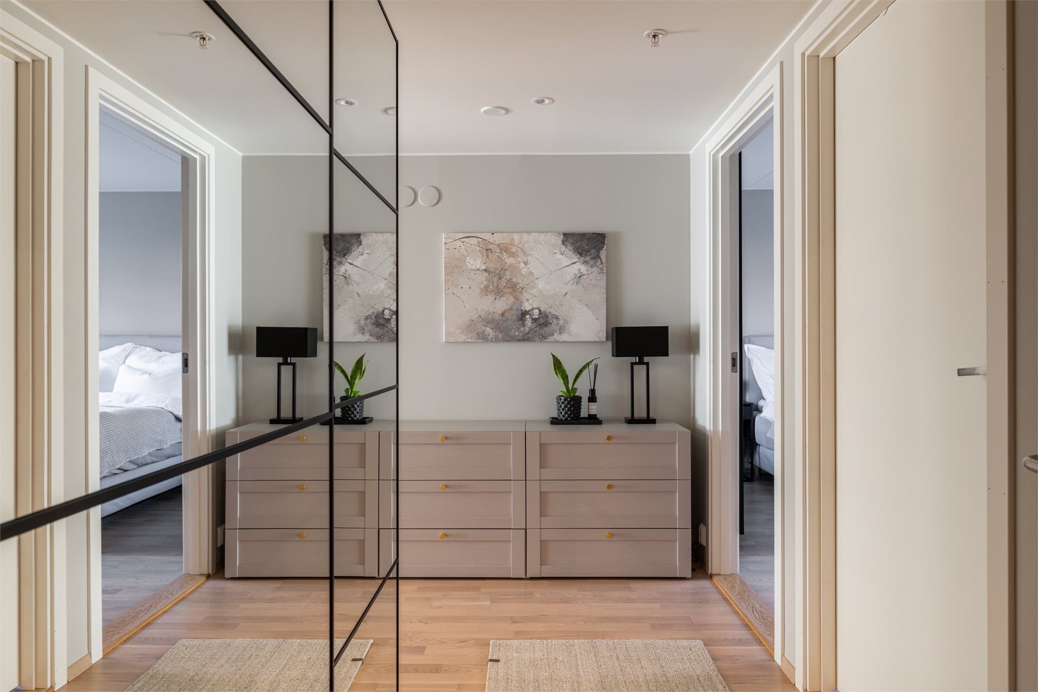 I entreen er det montert en romslig PAX skyvedørsgarderobe med speilfronter og sorte profiler, som gir oppbevaringsplass.