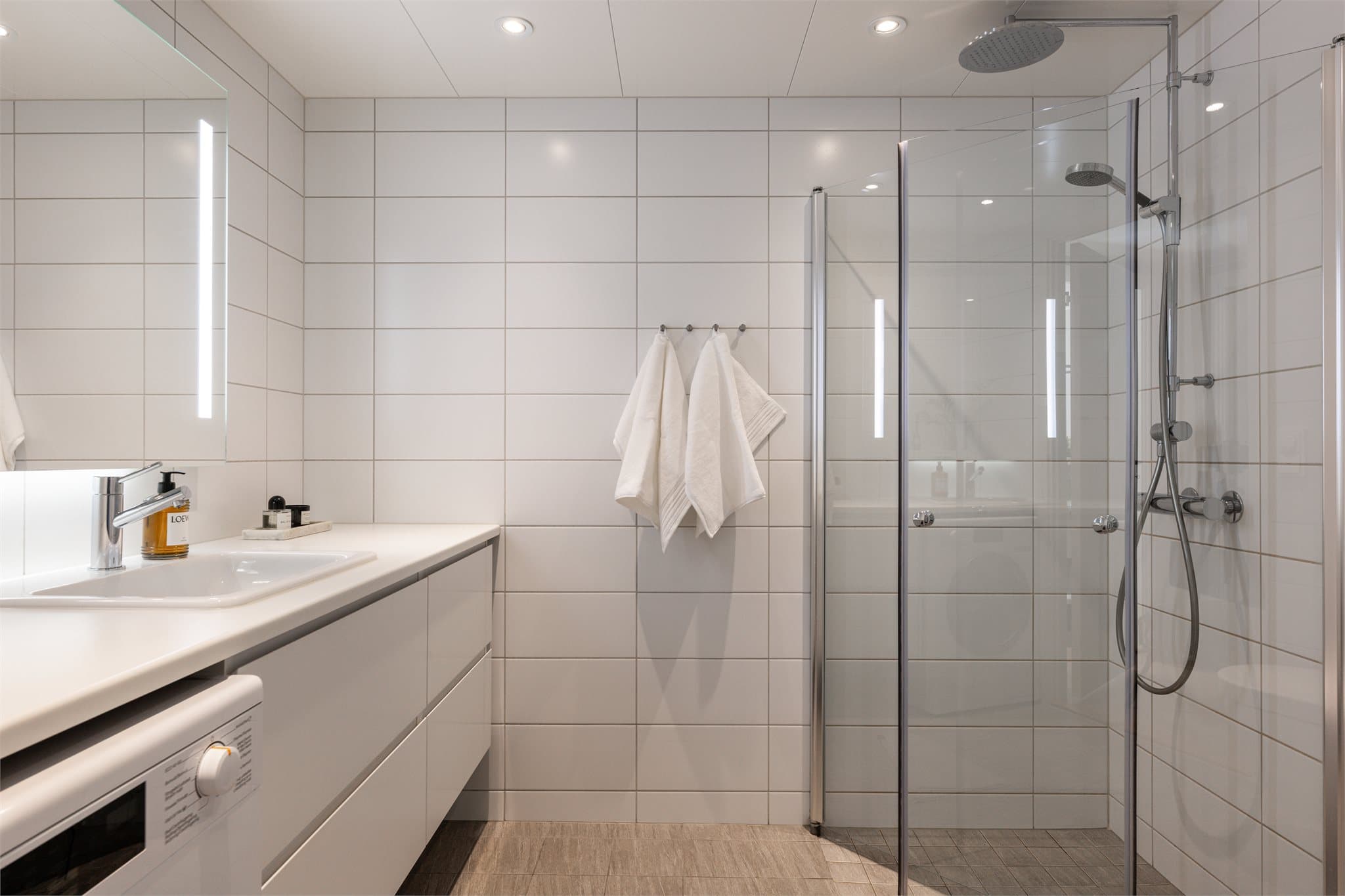 Flislagt bad med vannbåren gulvvarme og downlights i himlingen.