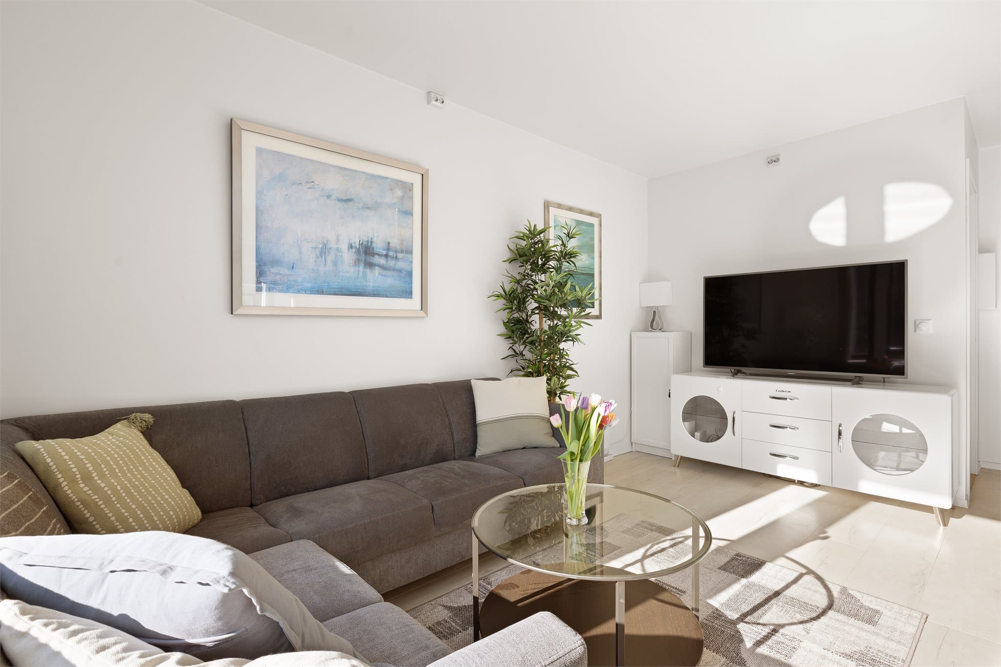 Stuen har god plass til en romslig sofagruppe og er et naturlig samlingspunkt i boligen.