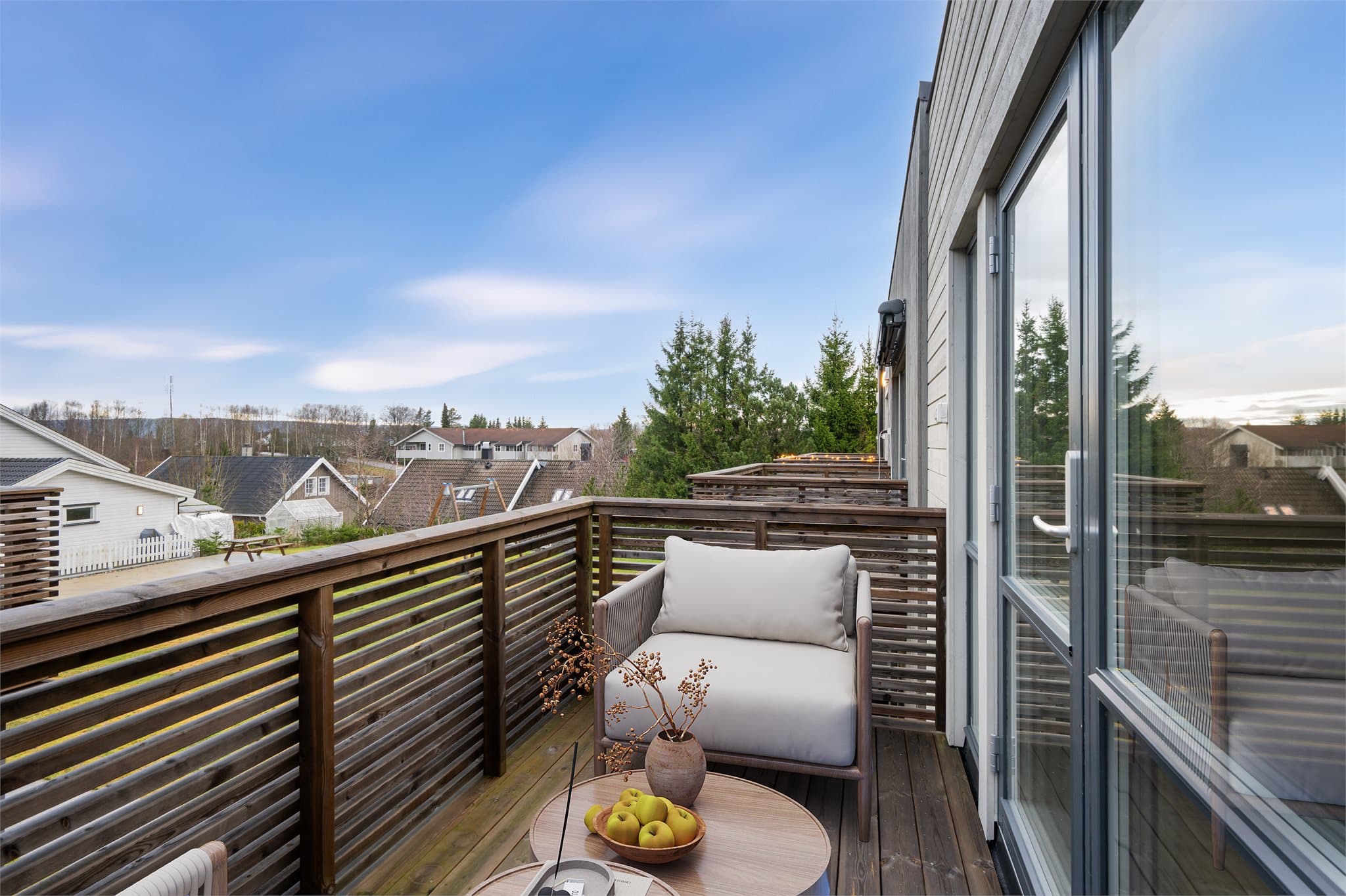 Balkongen vender ut mot sameiets fellesområde. Digitalt møblert.