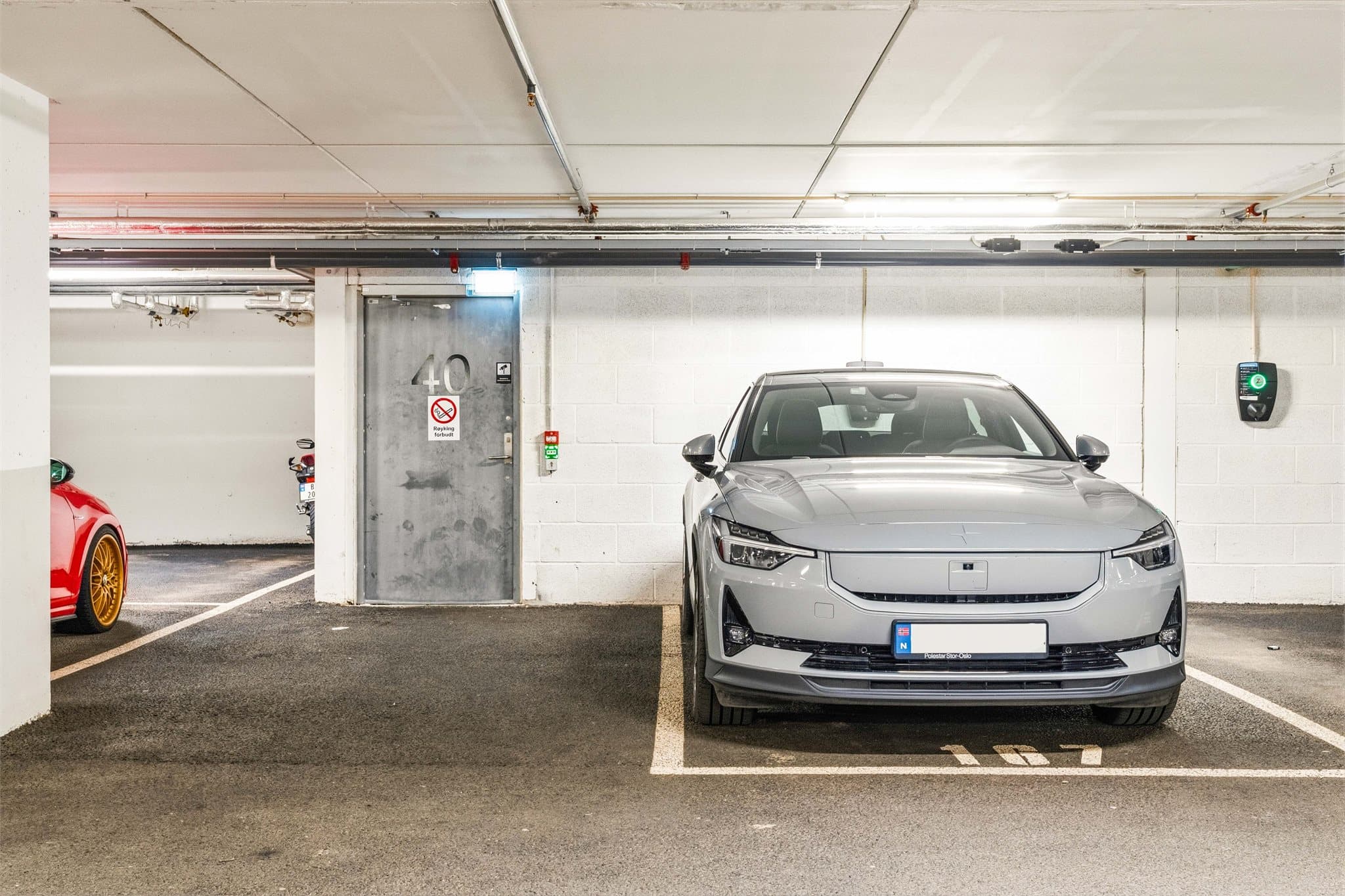 Leiligheten disponerer en garasjeplass med elbillader, beliggende rett ved inngangen til garasjen.