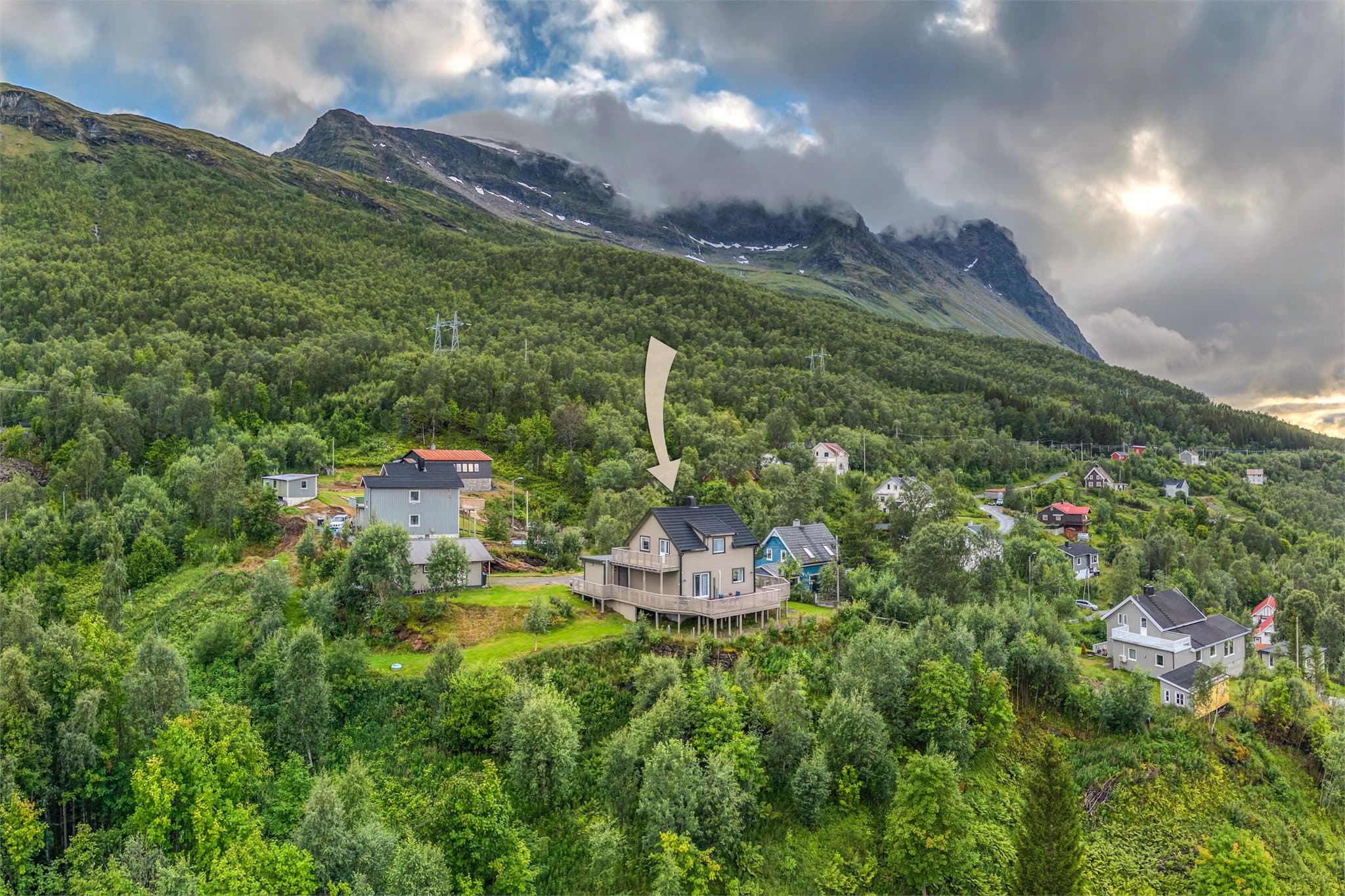 Eiendommen ligger høyt og fritt med utsikt over fjord og fjell.