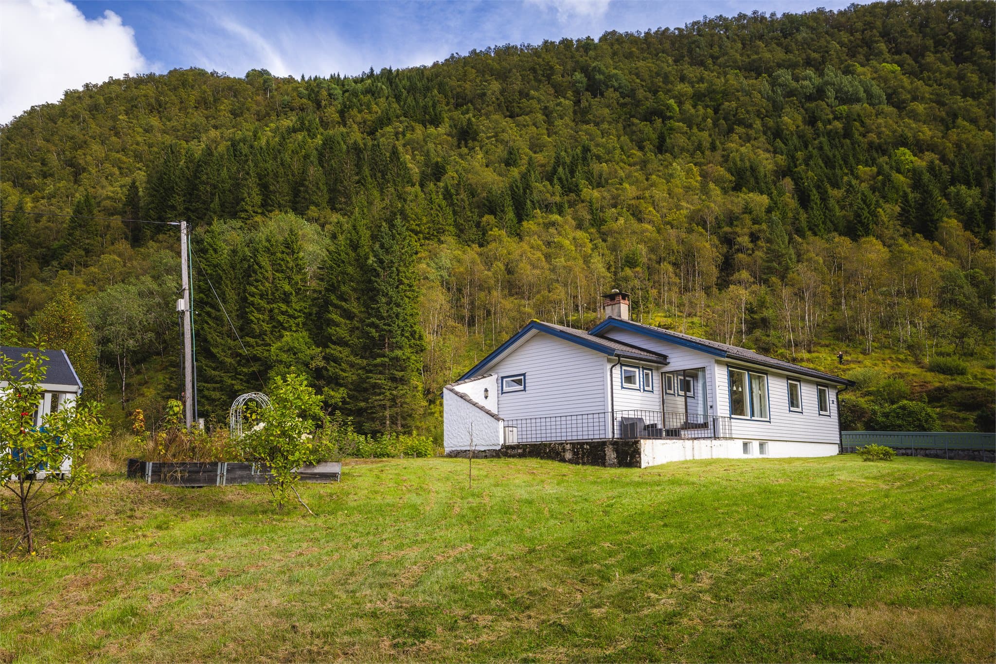 Her får man en godt opparbeidet tomt med garasje, hage, terrasseareal og et lite anneks