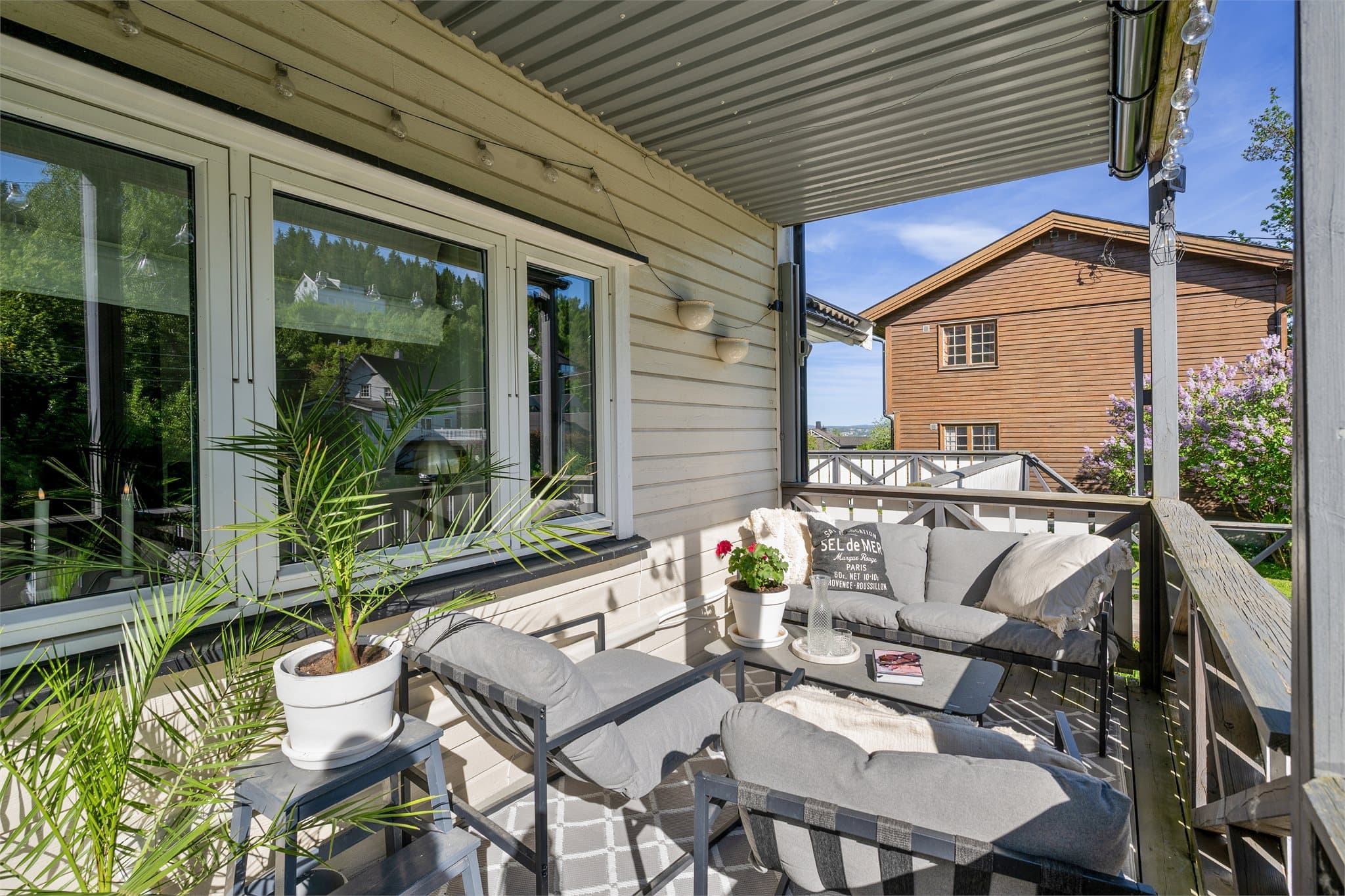 Romslig veranda med plass til sittegruppe.