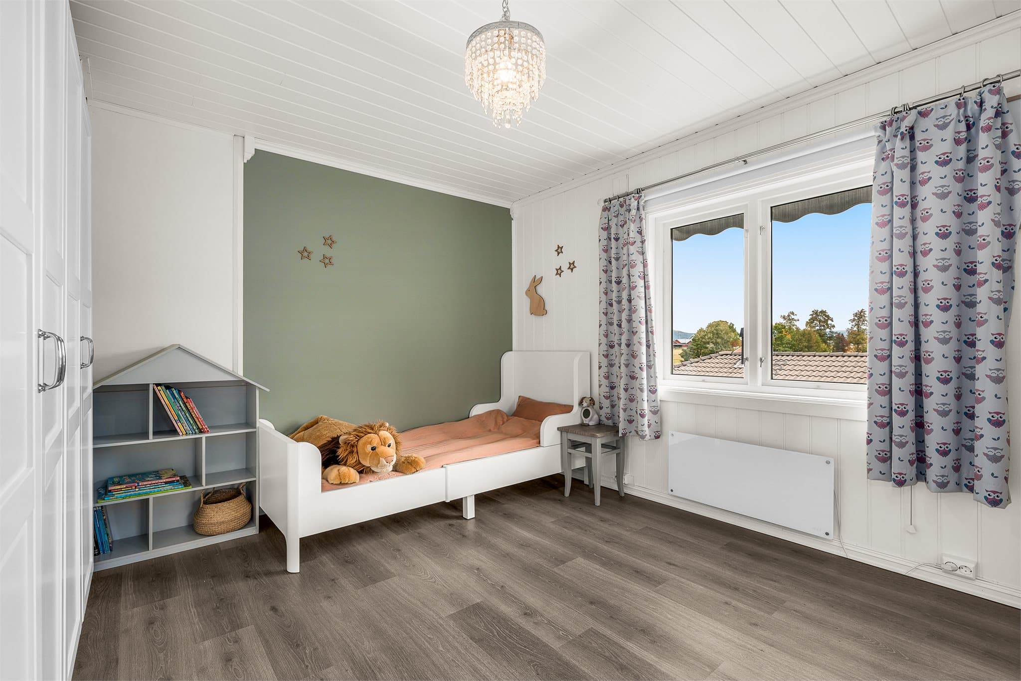 Lyst og hyggelig soverom med plass til seng og oppbevaring.