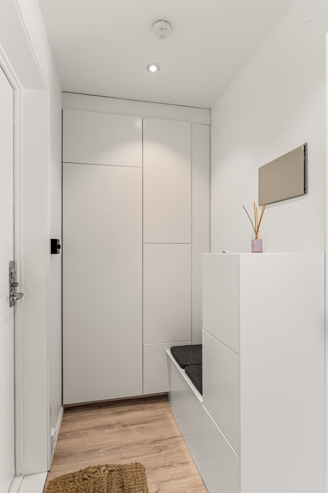 Lys og åpen entre, med downlights i tak. Et innebygget garderobeskap med glatte fronter gir plass til yttertøy uten at det tar av gulvarealet.