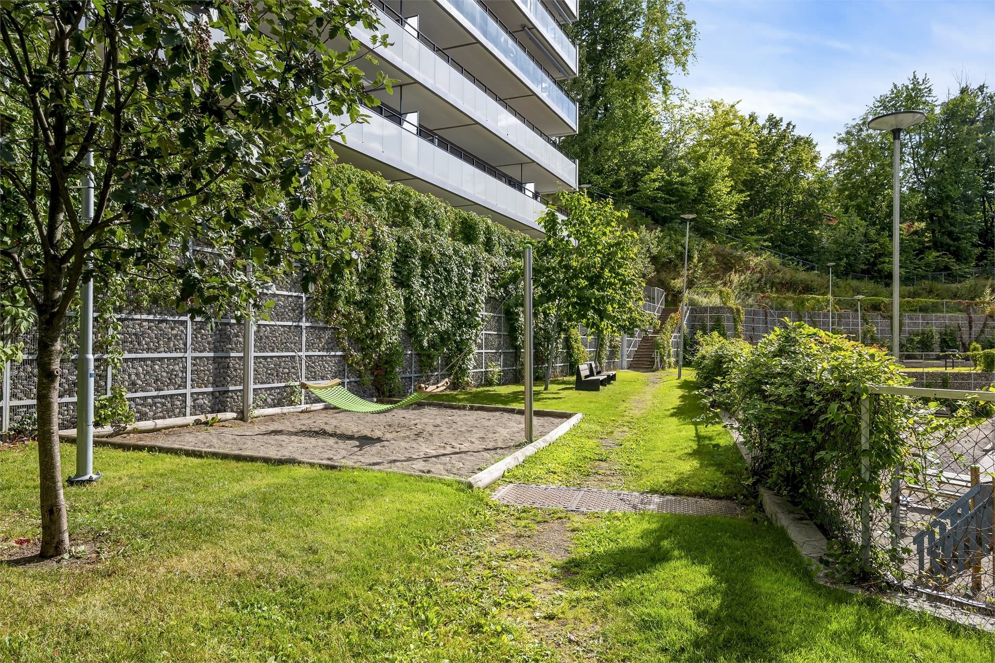Hyggelige fellesområder med hengekøyer, sittegrupper og grønne plenarealer for avslapning.