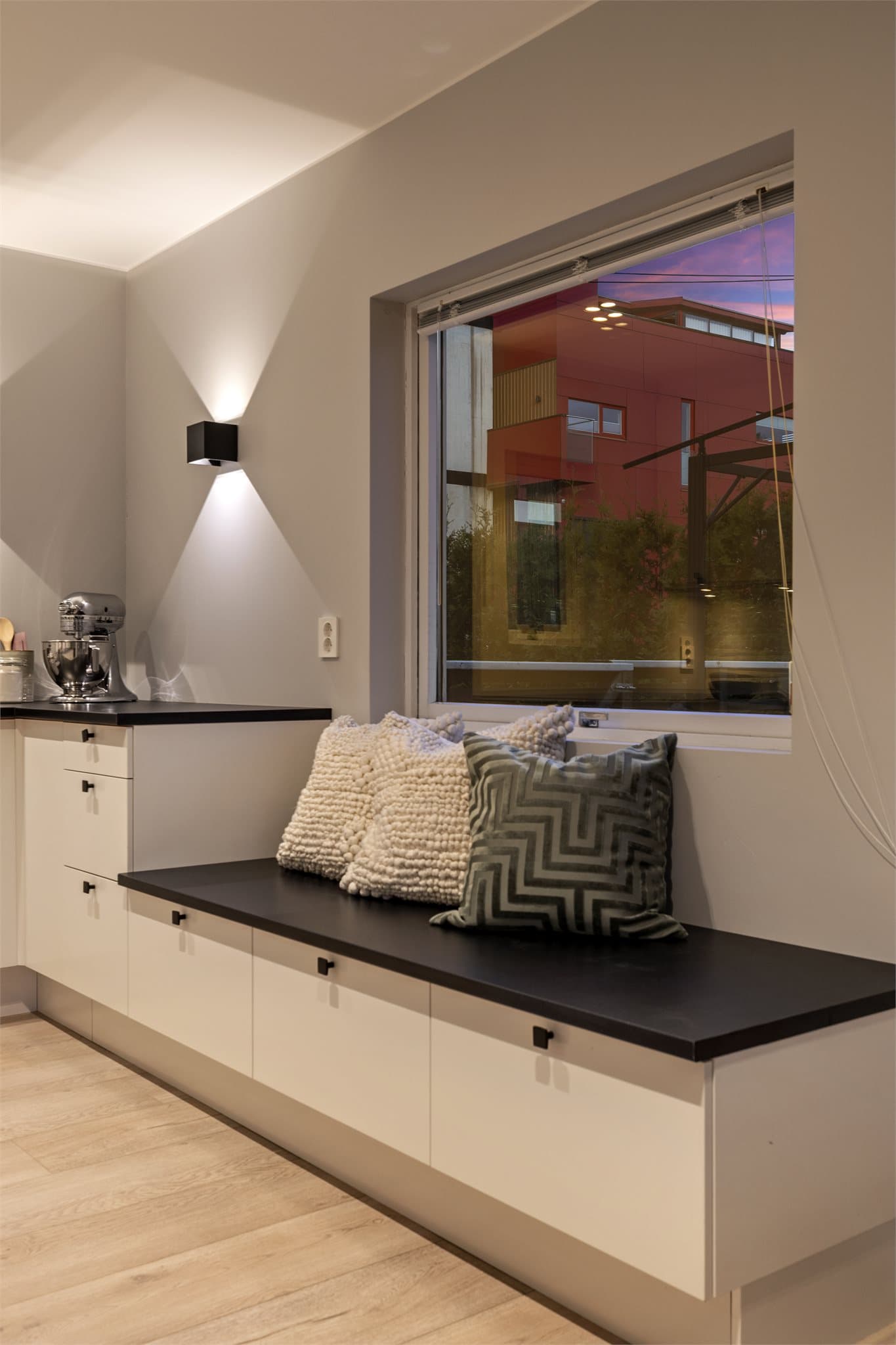 En smart, plassbygd benk med oppbevaring gir en hyggelig sitteplass ved vinduet.