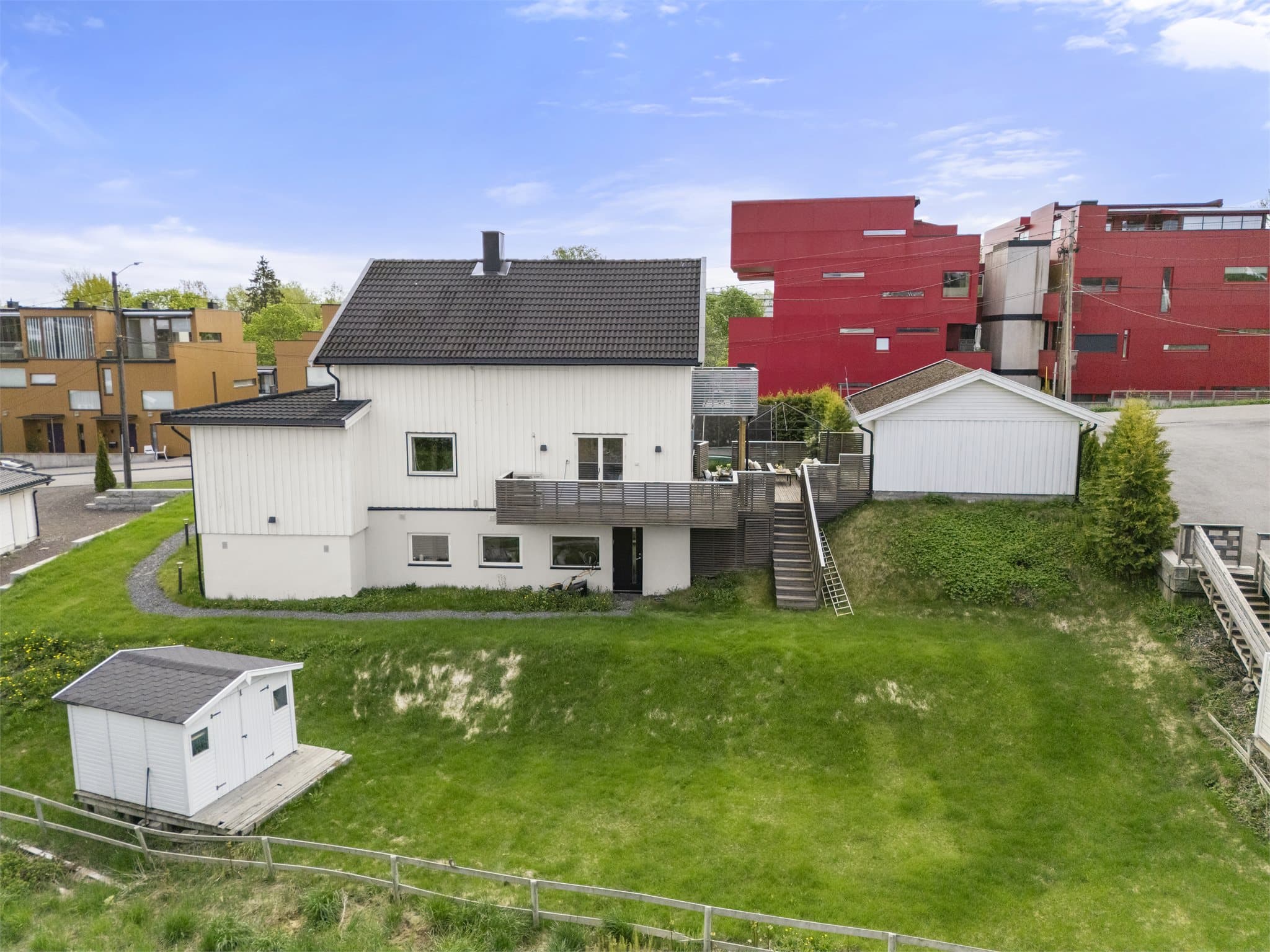 Oversiktsbilde av eiendommen med felles hage og privat terrasse.