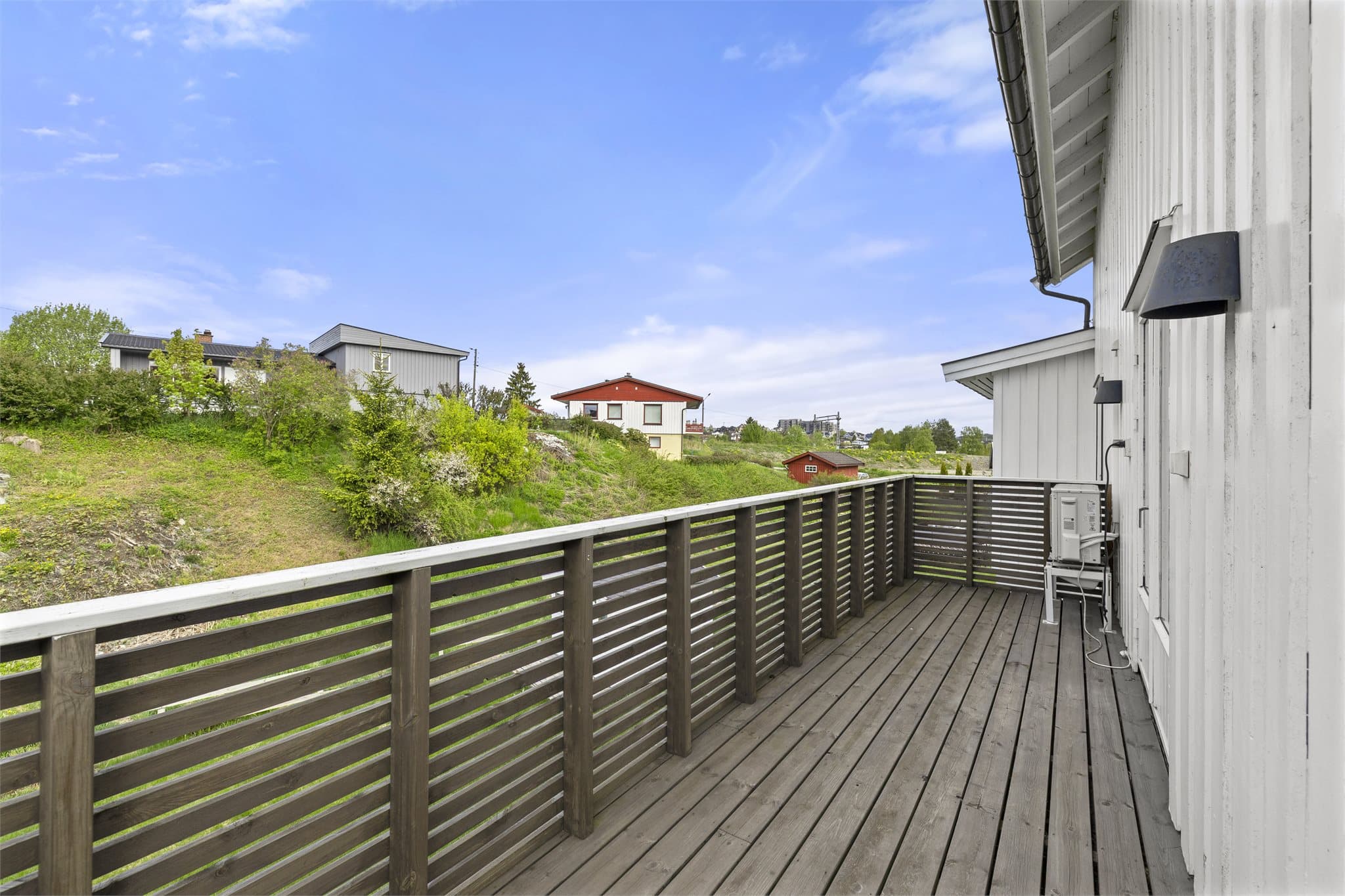 Stor terrasse med utsikt over hage.