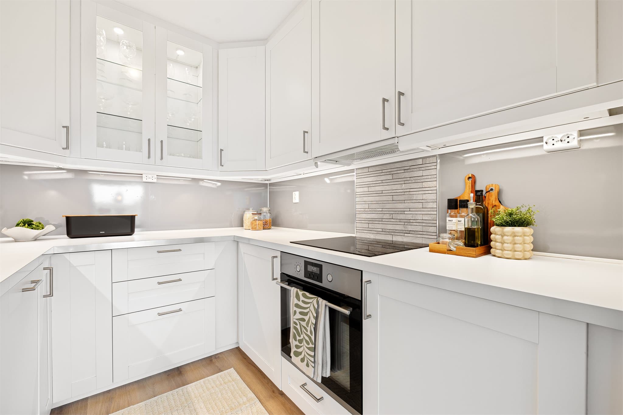 Lyst og pent kjøkken med profilerte fronter og benkeplate av laminat.