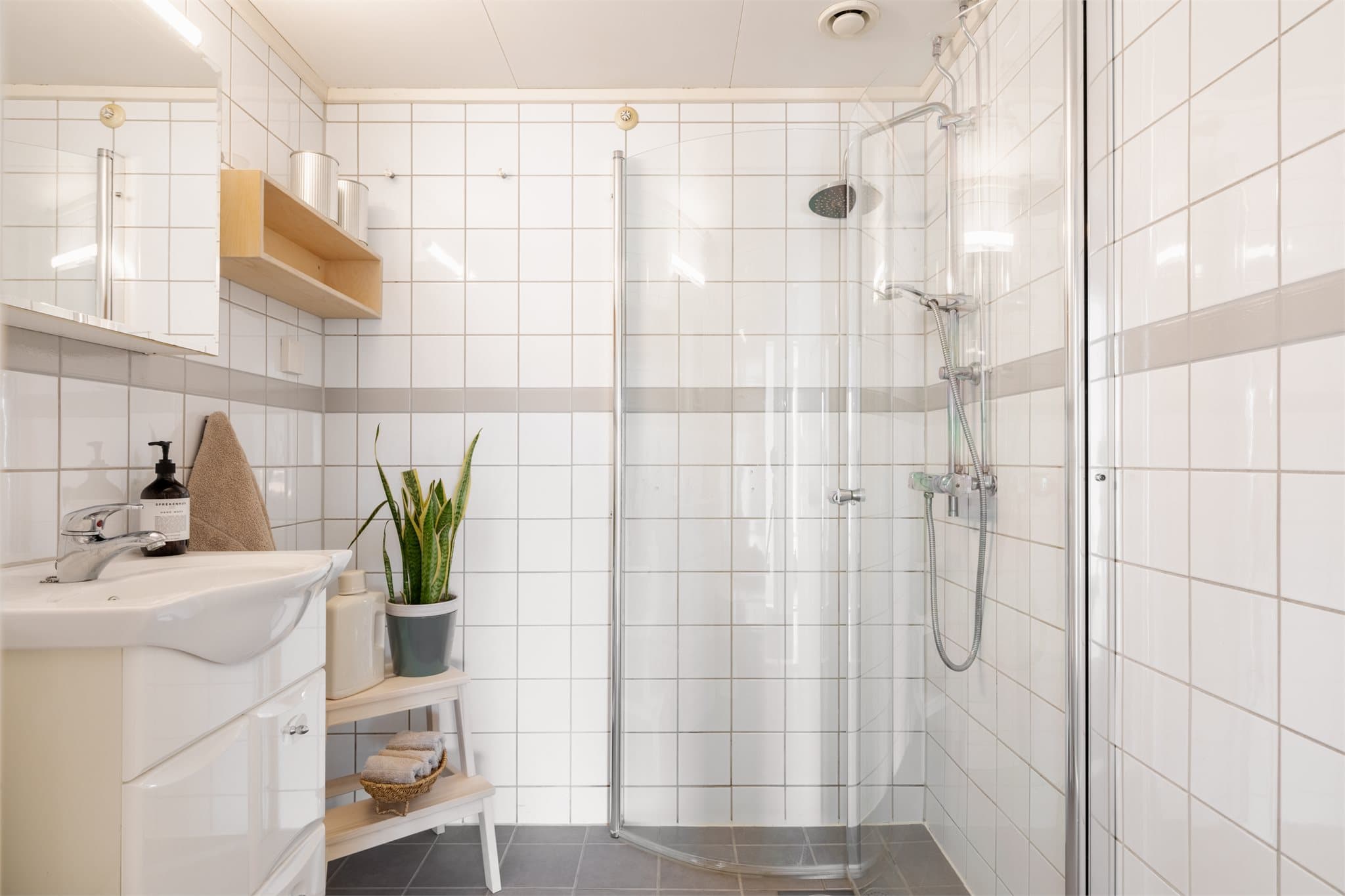 Badet er innredet med servant med skapinnredning, frittstående klosett og dusj på gulv. Det er opplegg for vaskemaskin.