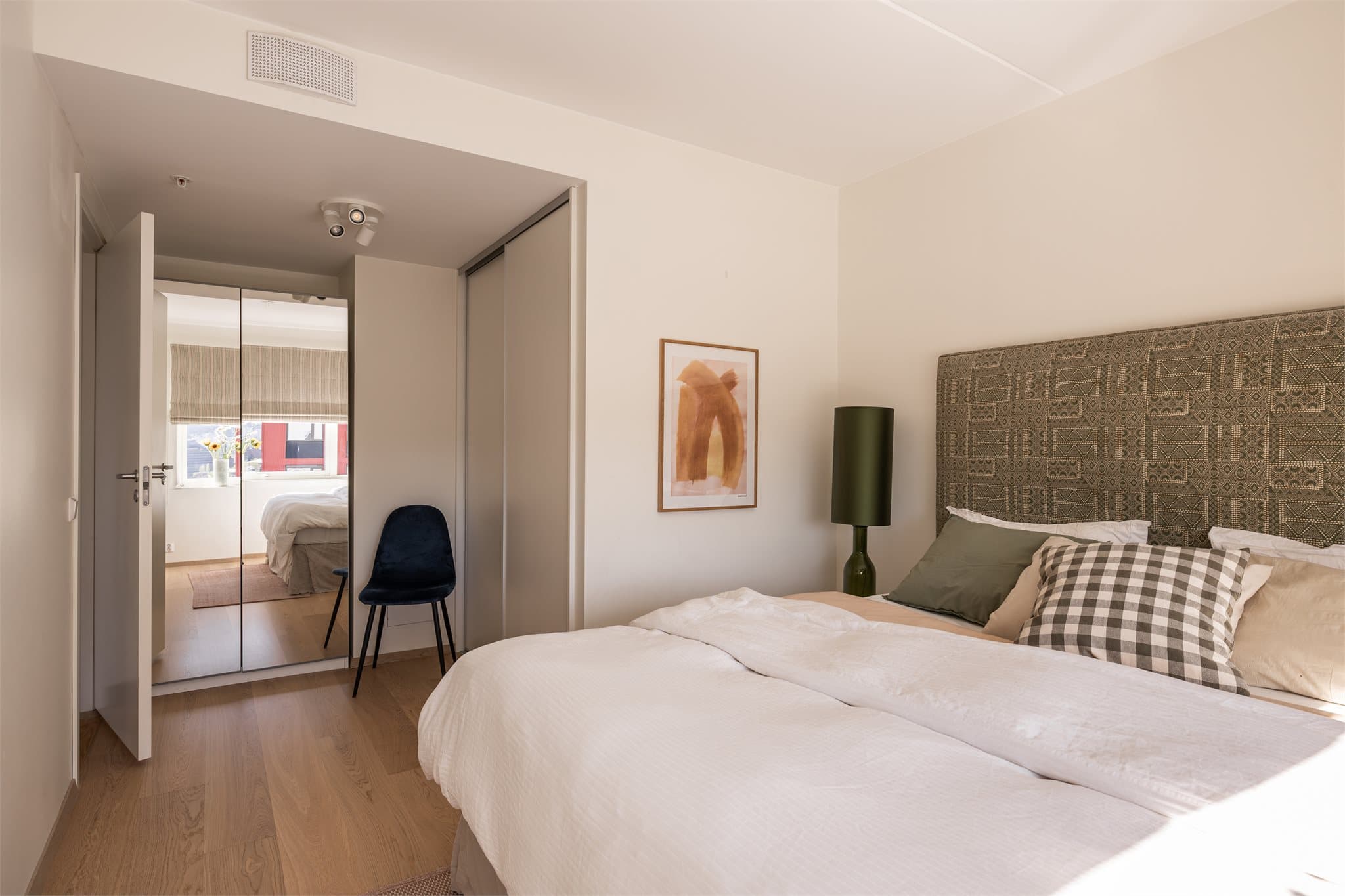 Rommet har veldig god skapplass med plassbygget skyvedørsgarderobe i tillegg til speilskap.