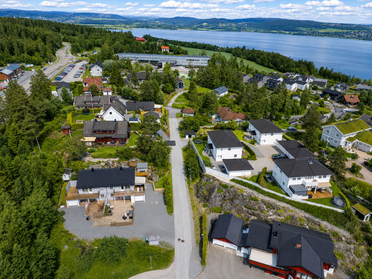 Dronebildet viser den familievennlige beliggenheten med skole og barnehage kun få minutters gange fra ytterdøren.