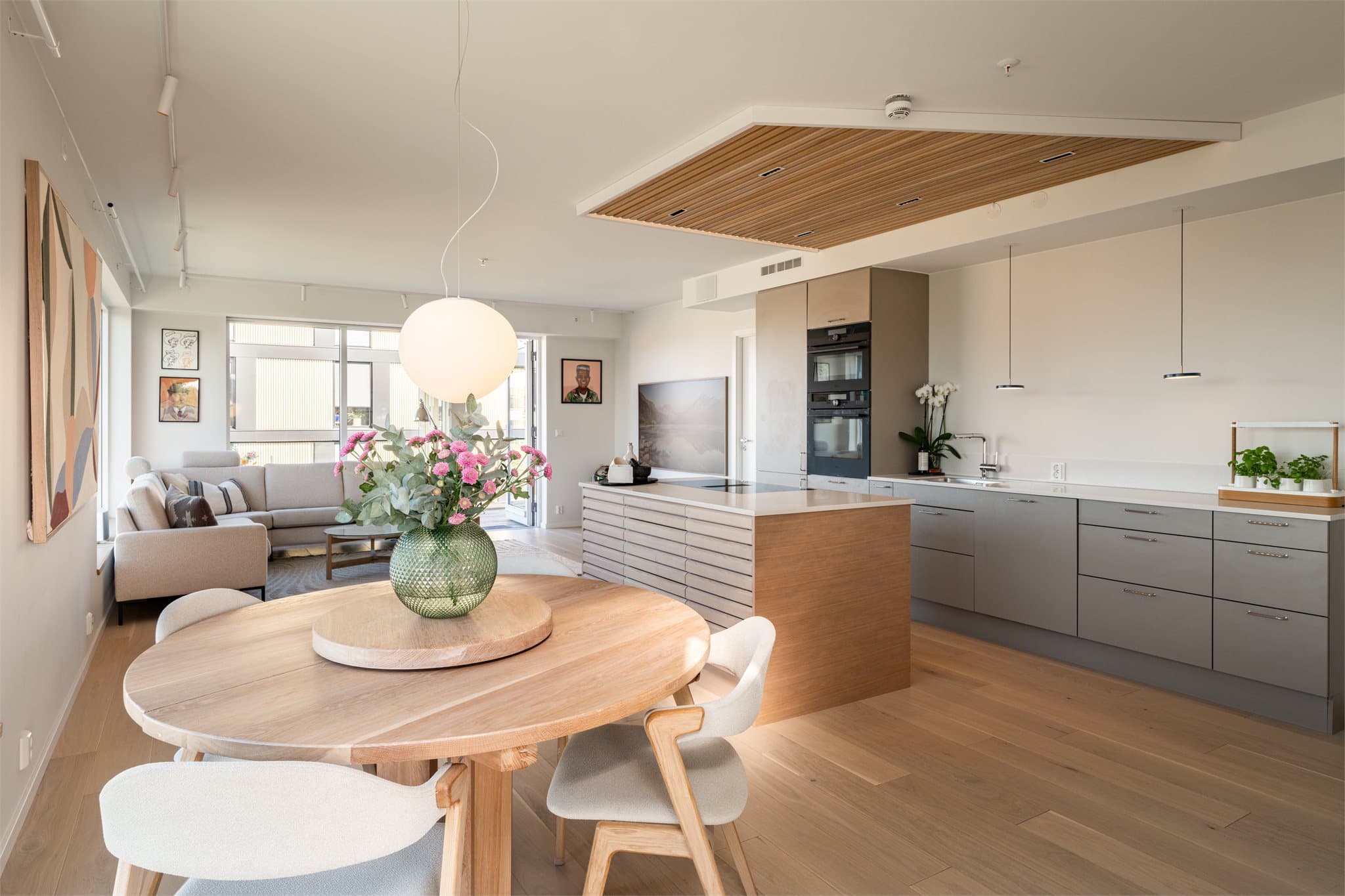 Den åpne løsningen mellom stue og kjøkken skaper en sosial og romslig atmosfære.