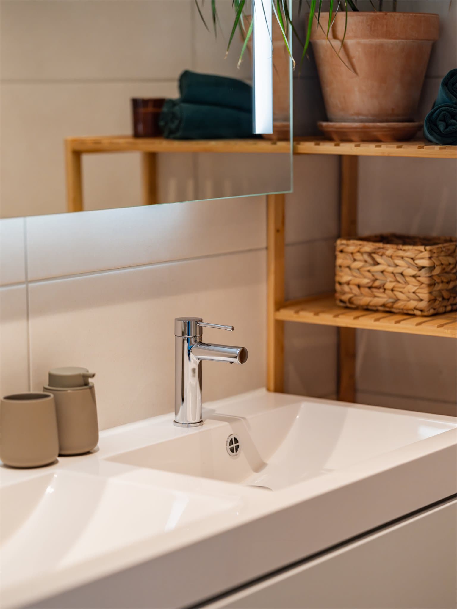 Baderomsinnredningen er moderne med servant og speil med integrert belysning.