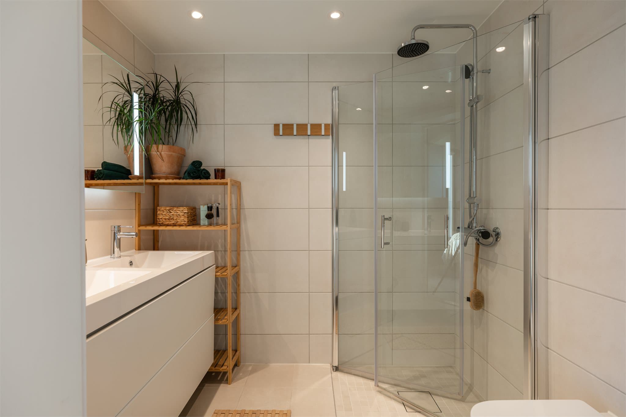 Det ene av to fullverdige bad, med dusjhjørne med regndusj og glassvegg.