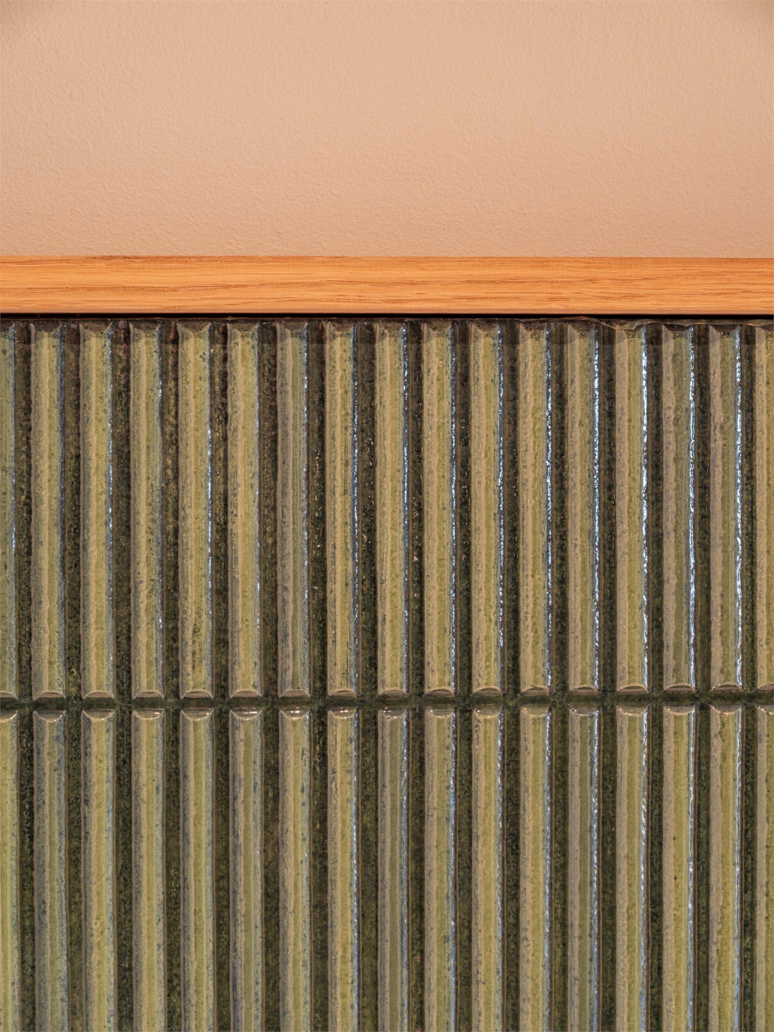 Detaljer som de grønne, glaserte flisene tilfører boligen karakter.