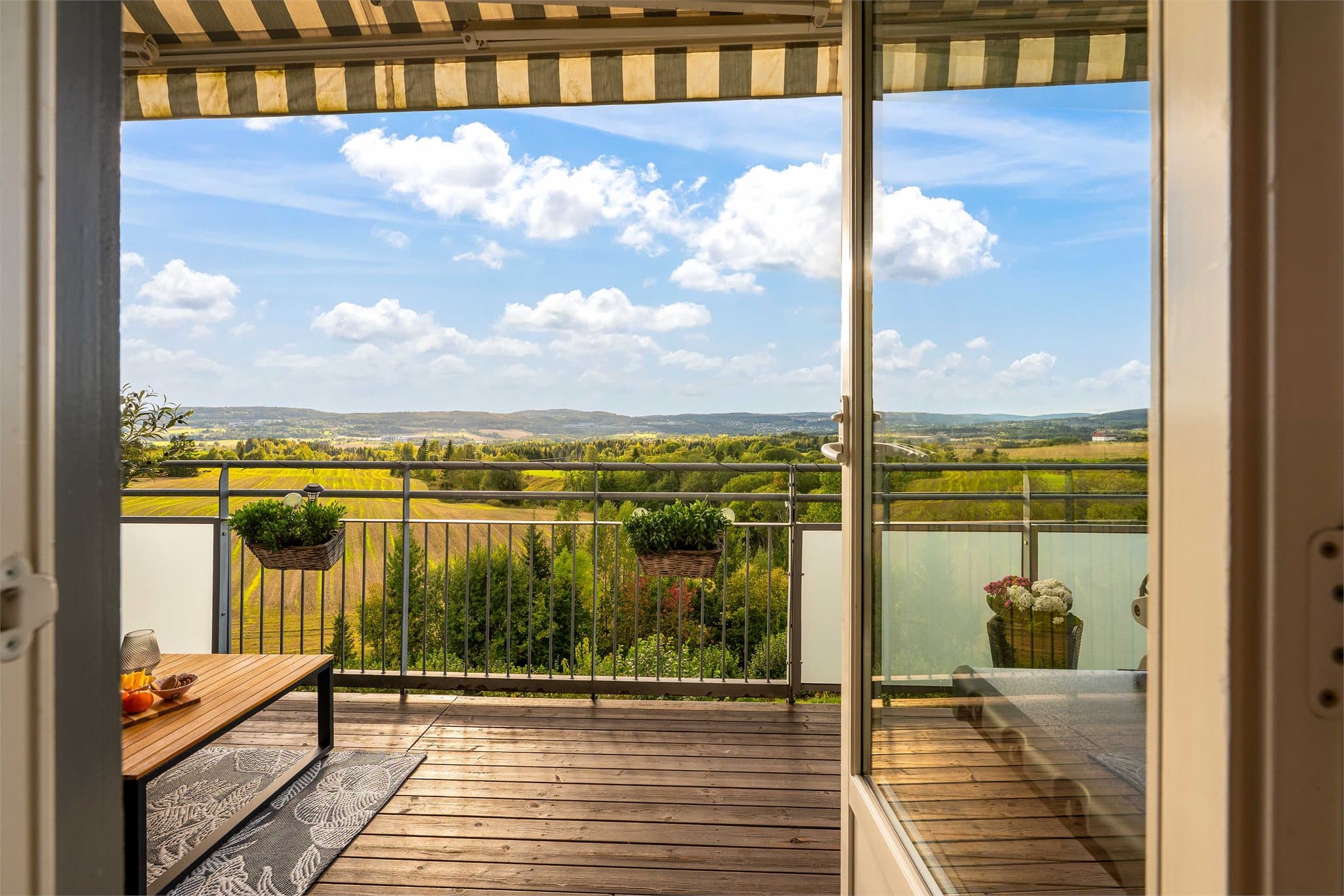 Bilder fra sommer/høst 2025. Fra stuen er det utgang til solrik balkong på ca. 13,5 kvm som tilbyr fantastisk utsikt over naturskjønne omgivelser. Her kan man nyte solnedganger.