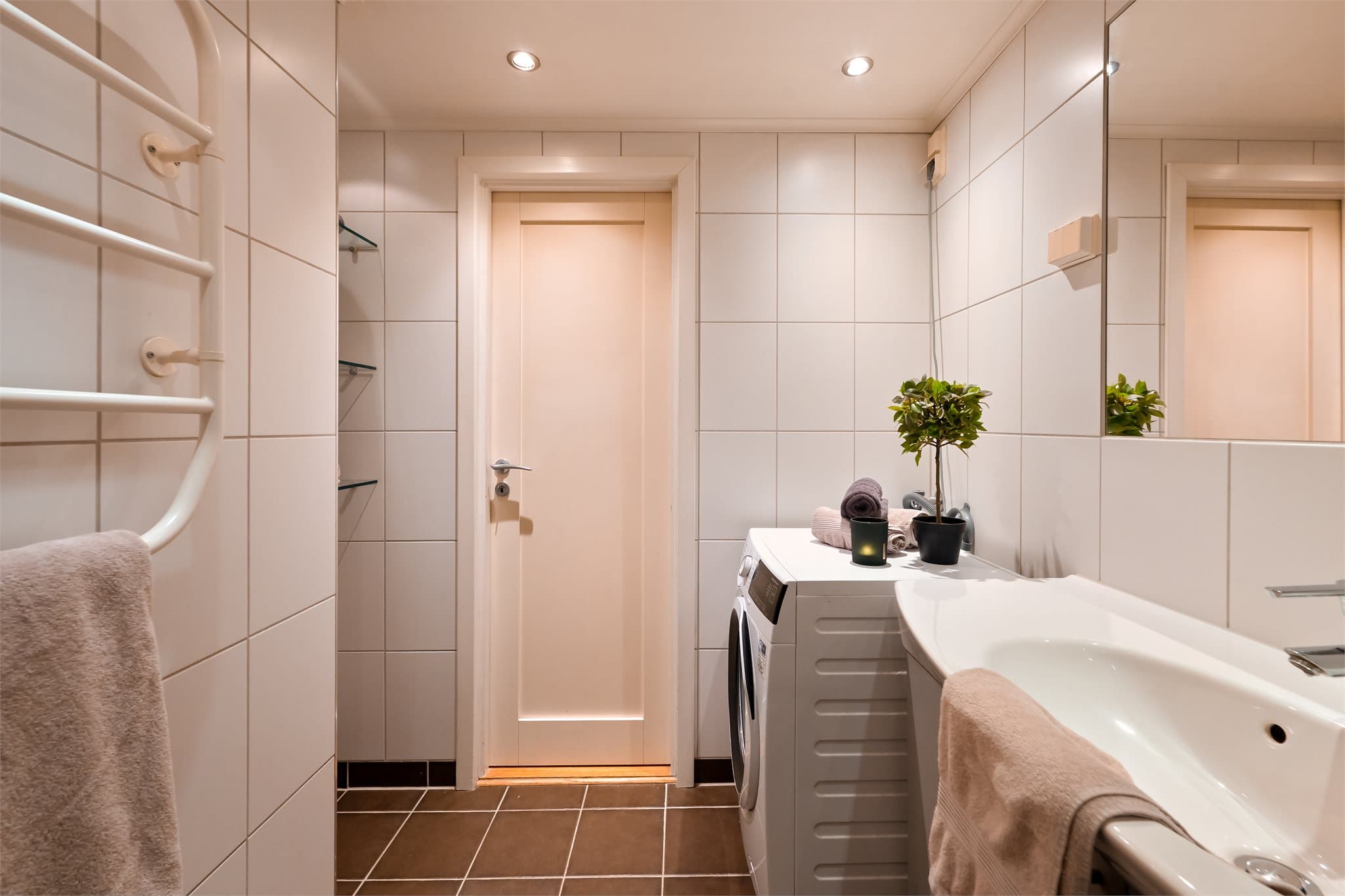 Rommet inneholder vegghengt toalett, dusjhjørne samt servant med tilhørende skapplass.