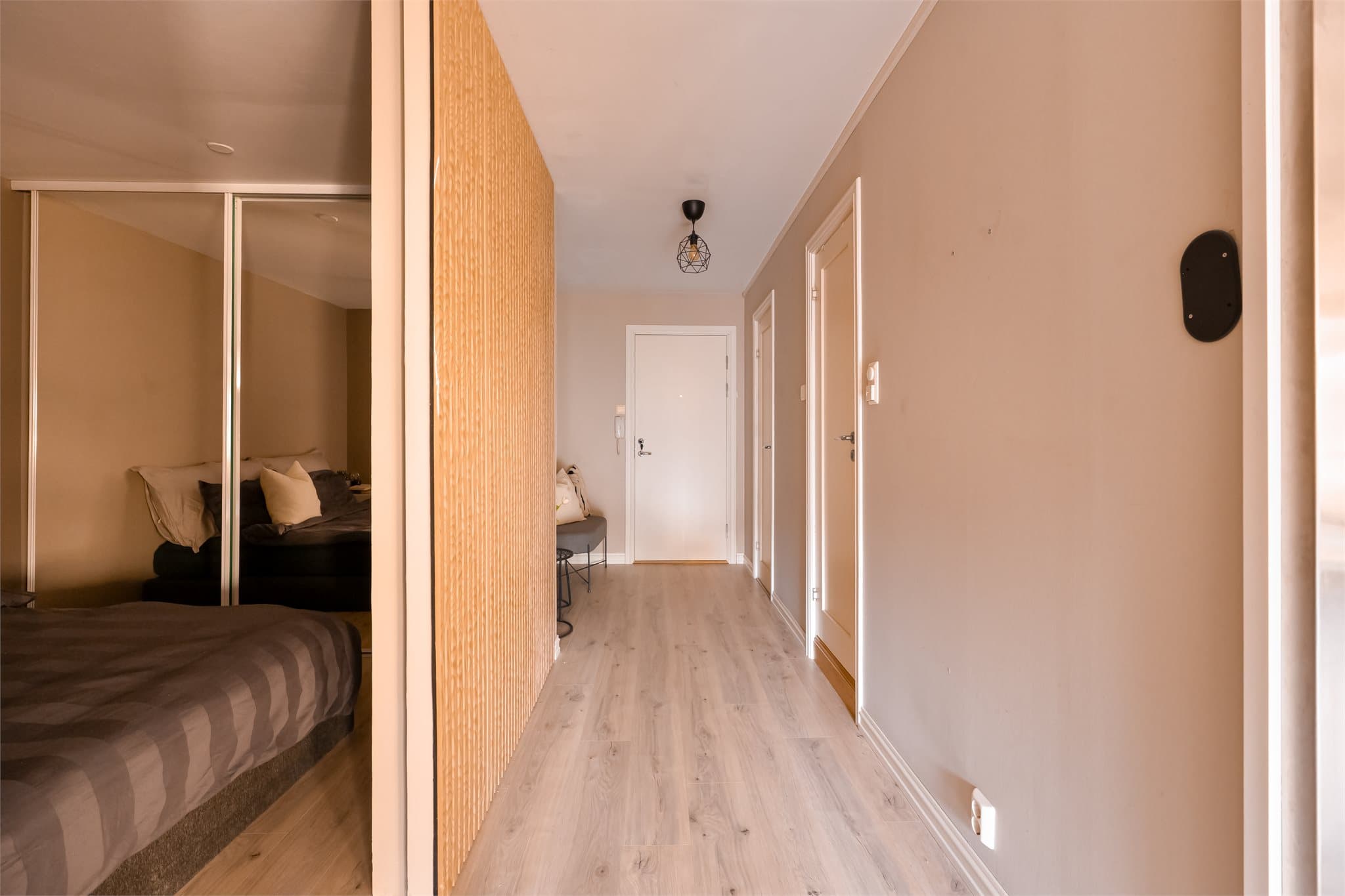 Rommet har skyvedør med spiler, noe som gir et moderne og lekkert uttrykk.