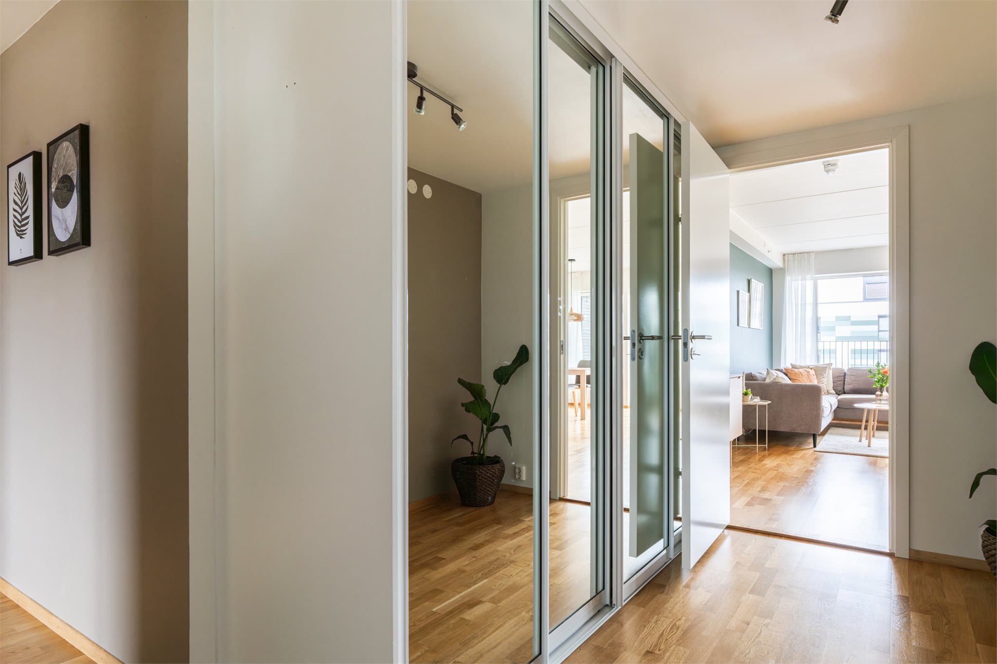 En stor skyvedørsgarderobe med speilfronter gir rikelig med oppbevaringsplass i gangen.