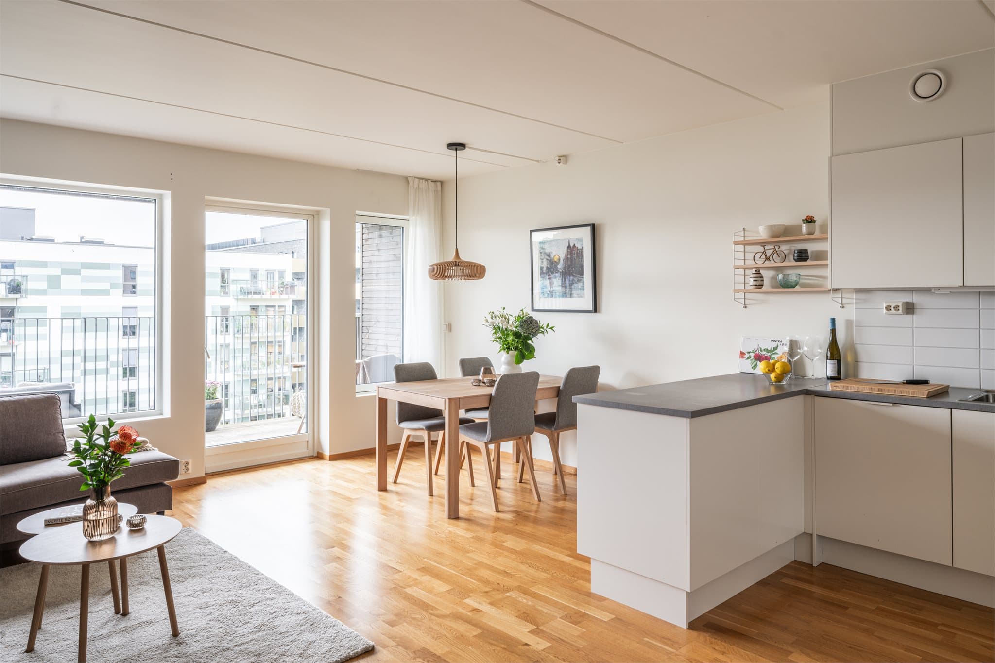 Den åpne løsningen mellom stue og kjøkken gir en sosial og luftig atmosfære.