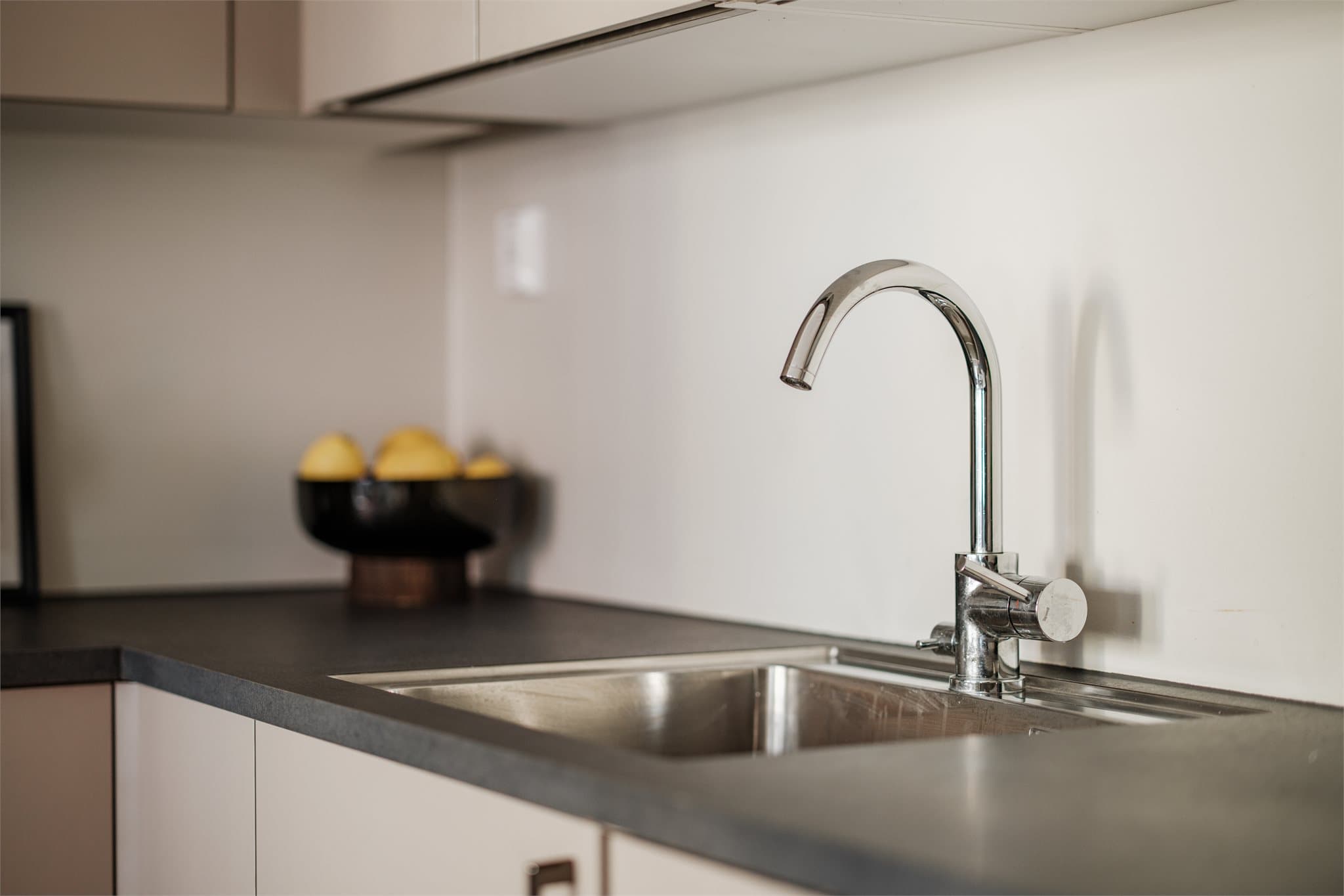 Kjøkkeninnredning med glatte fronter. Laminat benkeplate med nedfelt vaskekum.