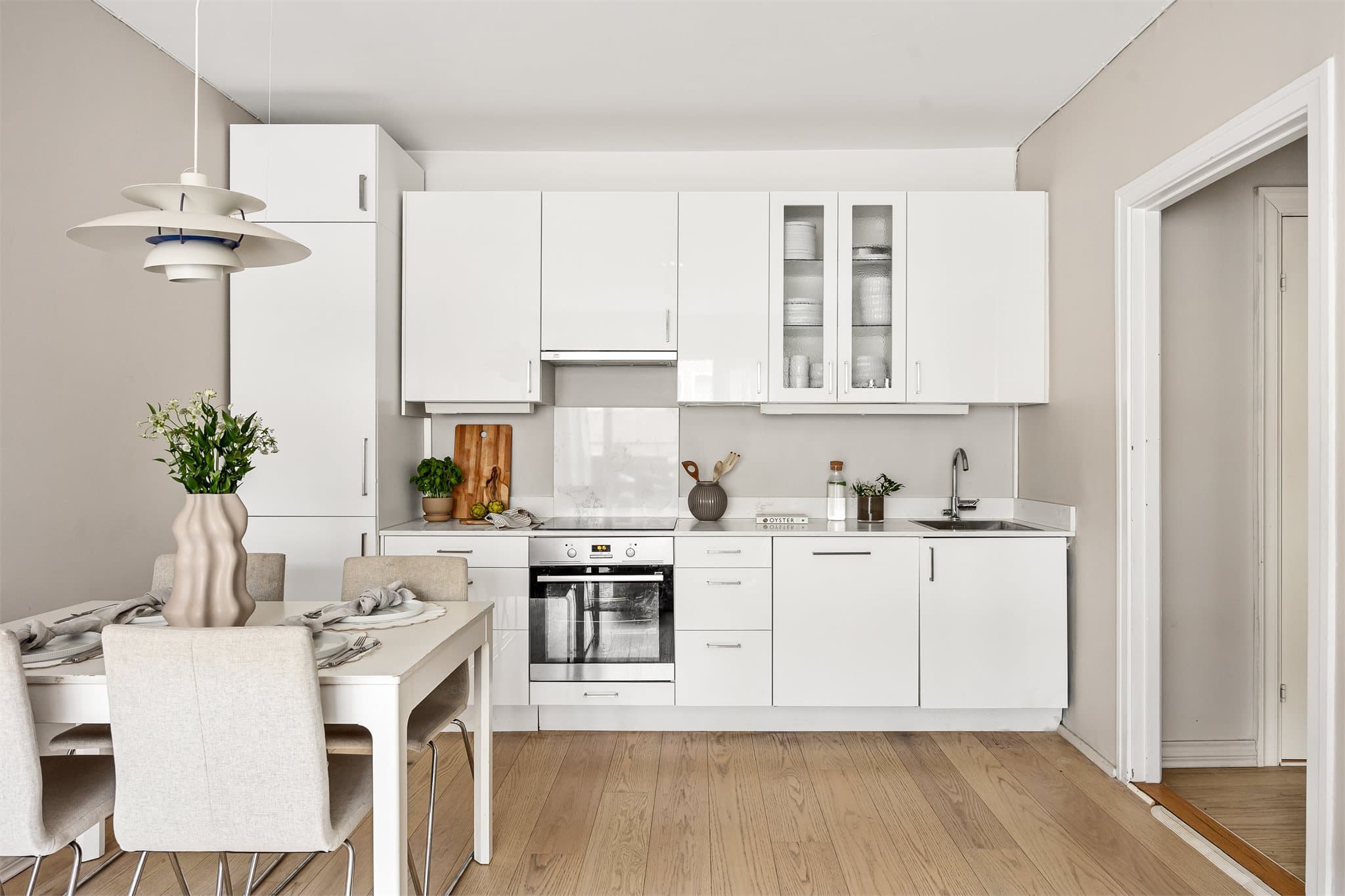 Det lyse kjøkkenet har slette fronter og en praktisk utforming med god oppbevaringsplass.