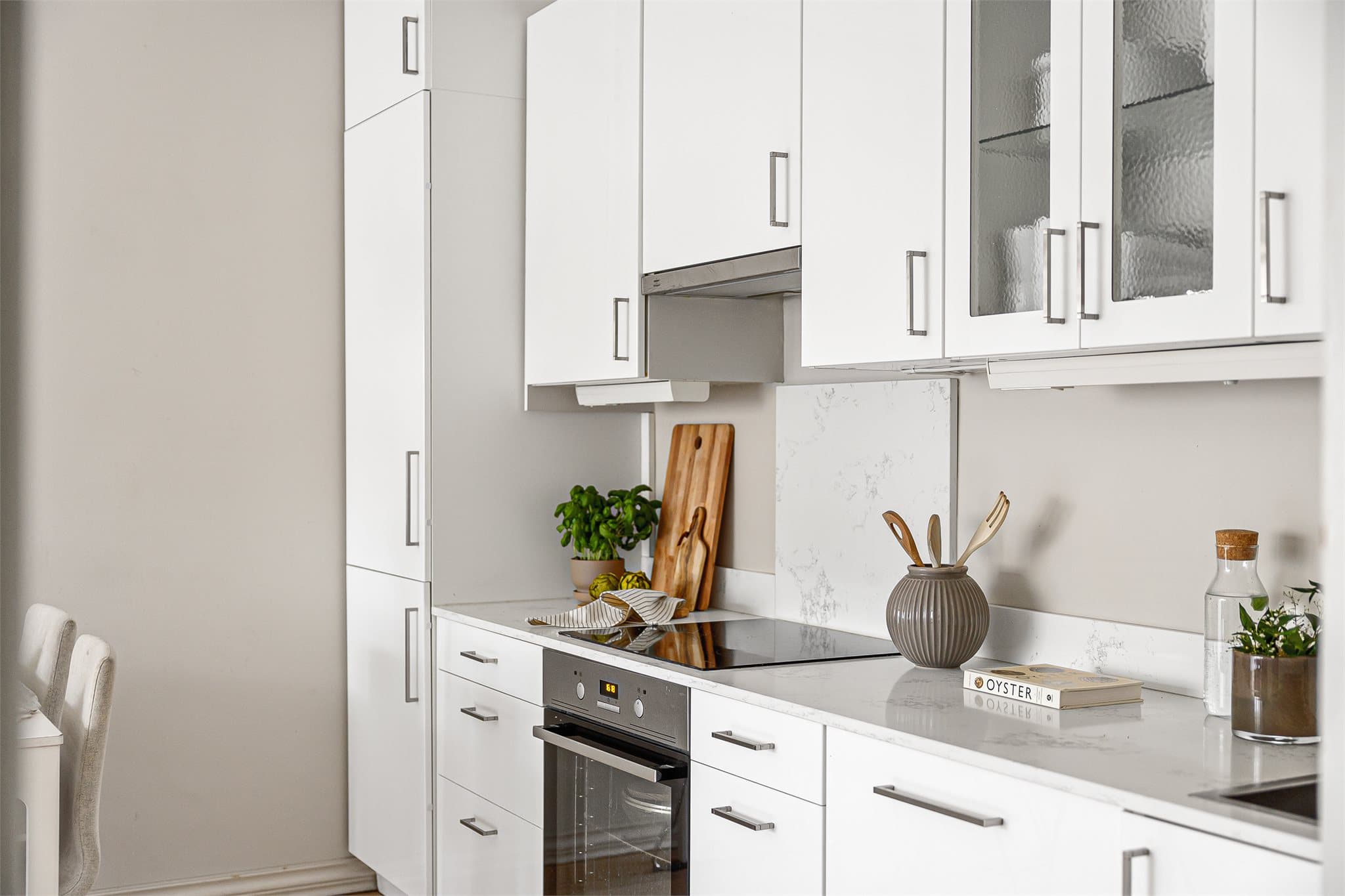 Moderne innredning med integrerte hvitevarer og backsplash.