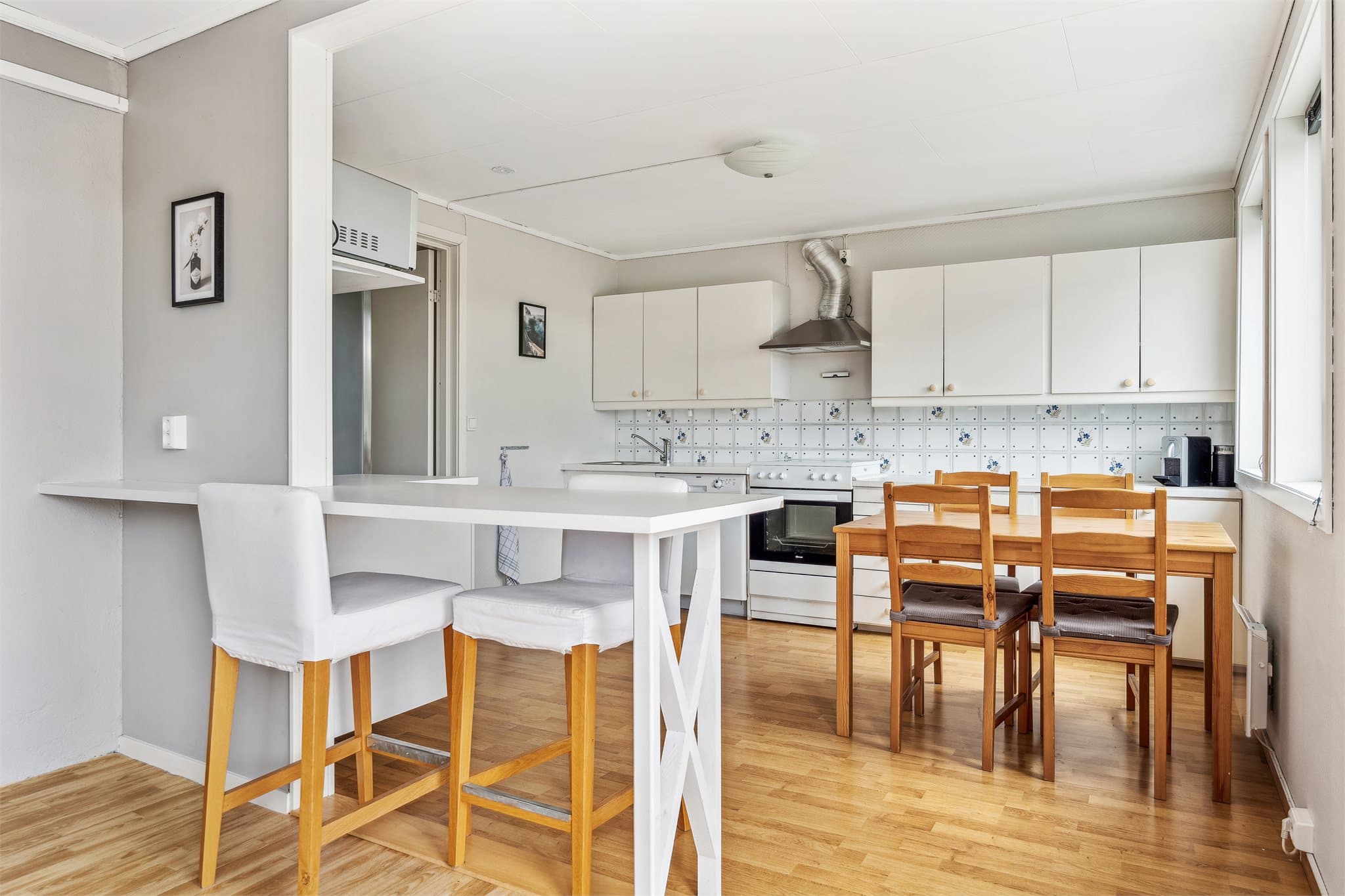Lyst og romslig kjøkken med kjøkkenbord og plass til spisestue, perfekt for både hverdag og selskap.