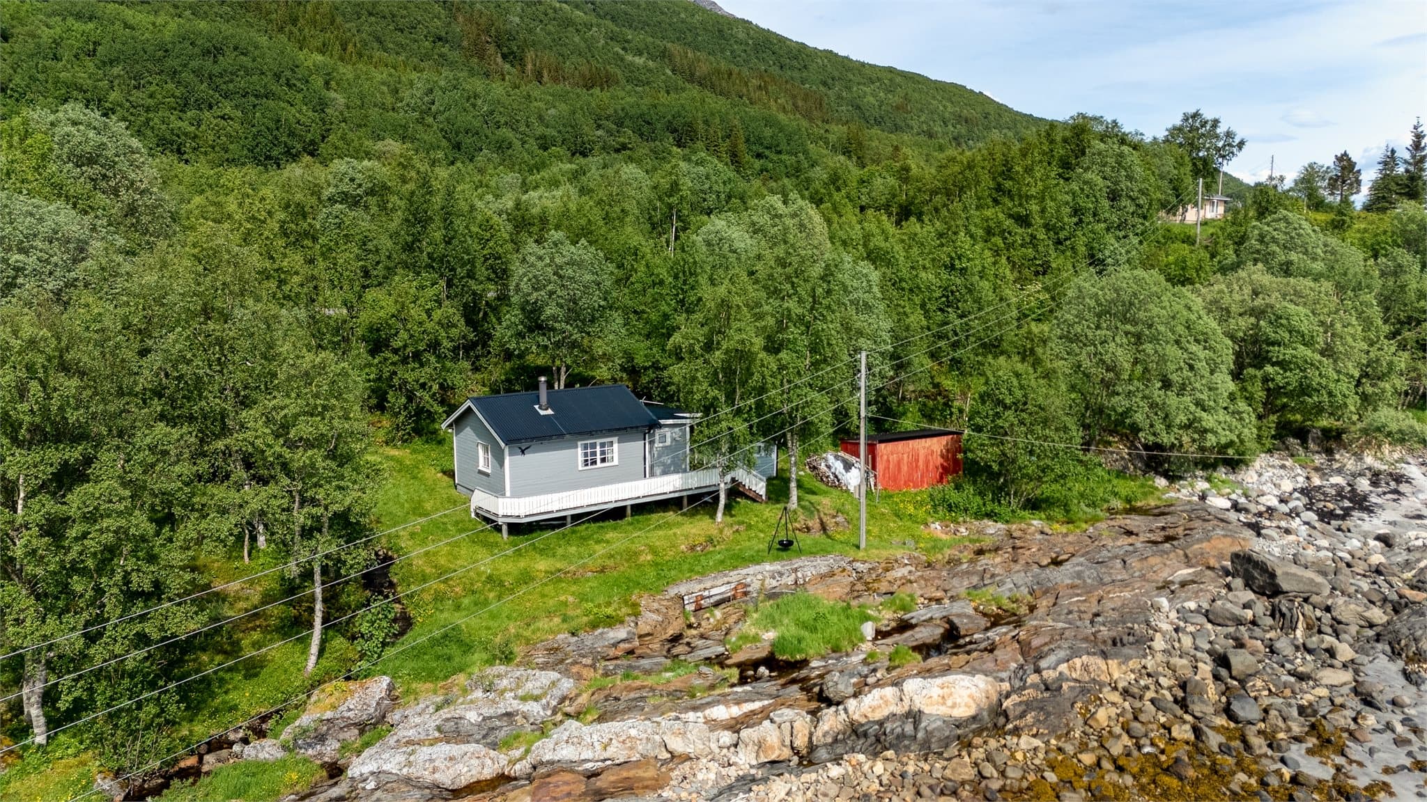 Hytta fra 1976 er fundamentert på trestolper, med uthus for ekstra lagring.