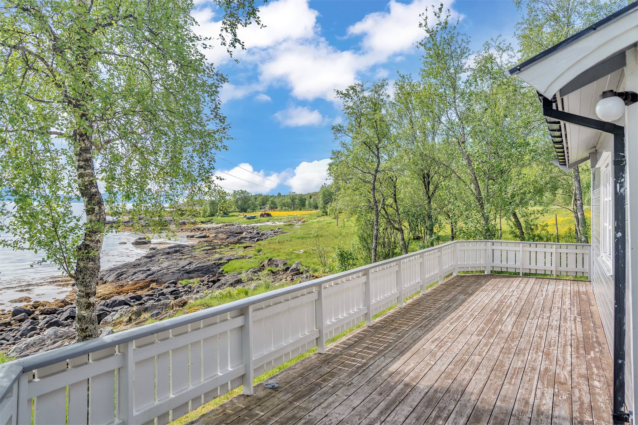 Stor terrasse på ca. 31 m² som strekker seg langs hyttas fasade mot sjøen.