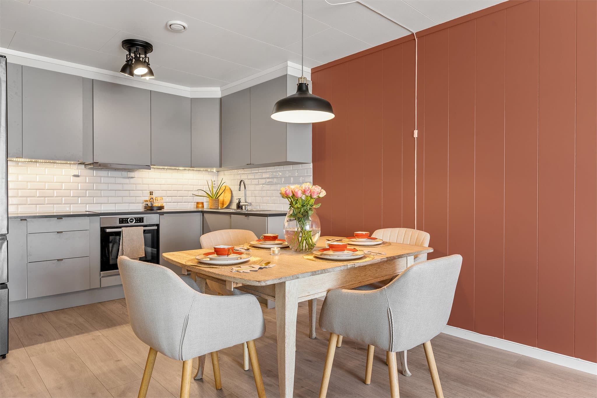 Kjøkkeninnredningen har slette fronter i fargen Mocca (Elfi fra Norema) og laminat benkeplate med koketopp og nedfelt oppvaskkum. Frontene ble byttet høstet 2025.