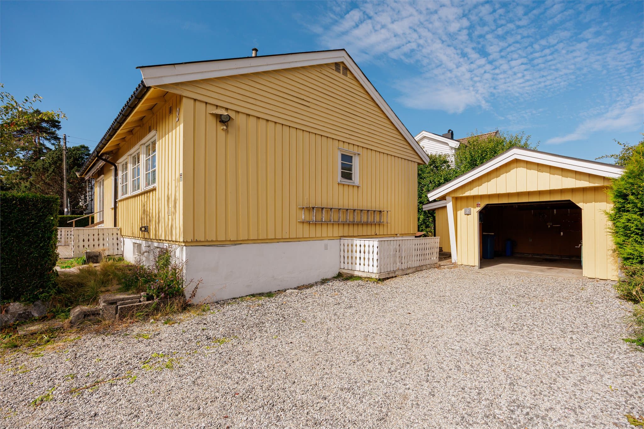 Eiendommen har en romslig parkeringsplass foran boligen, med god plass til flere biler. Innkjøringen gir enkel adkomst til garasjen.