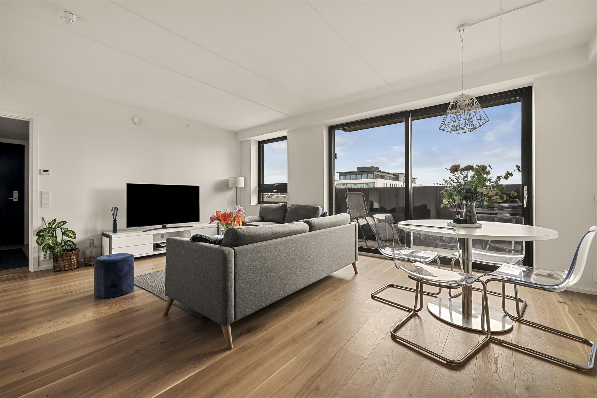 Moderne oppholdsrom med store vinduer, flott utsyn og naturlig samlingspunkt for både hverdag og gjester.