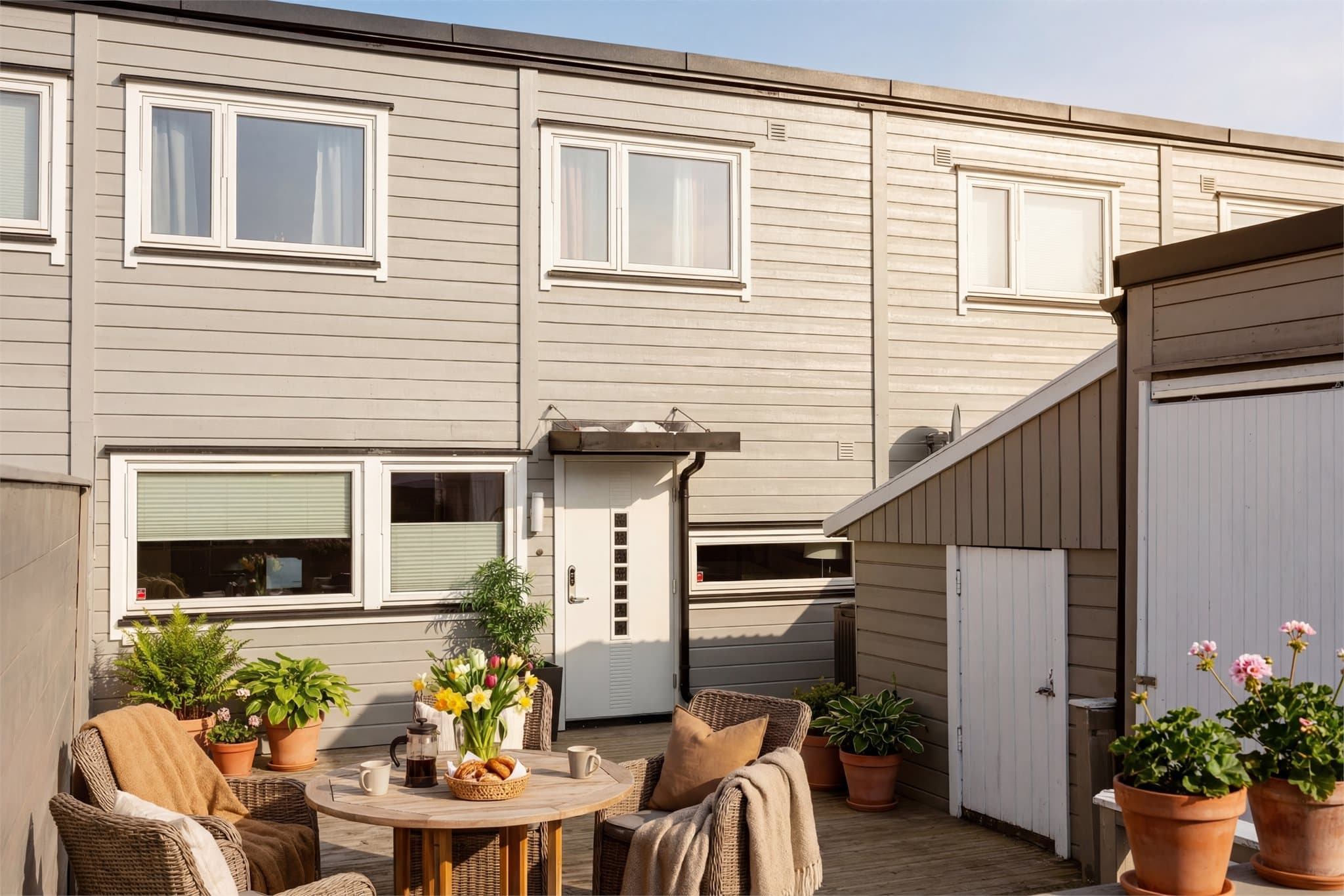 Terrasseplattingen på fremsiden skaper et hyggelig førsteinntrykk og er et perfekt sted for morgenkaffen i rolige omgivelser. (Ai -Digital styling)