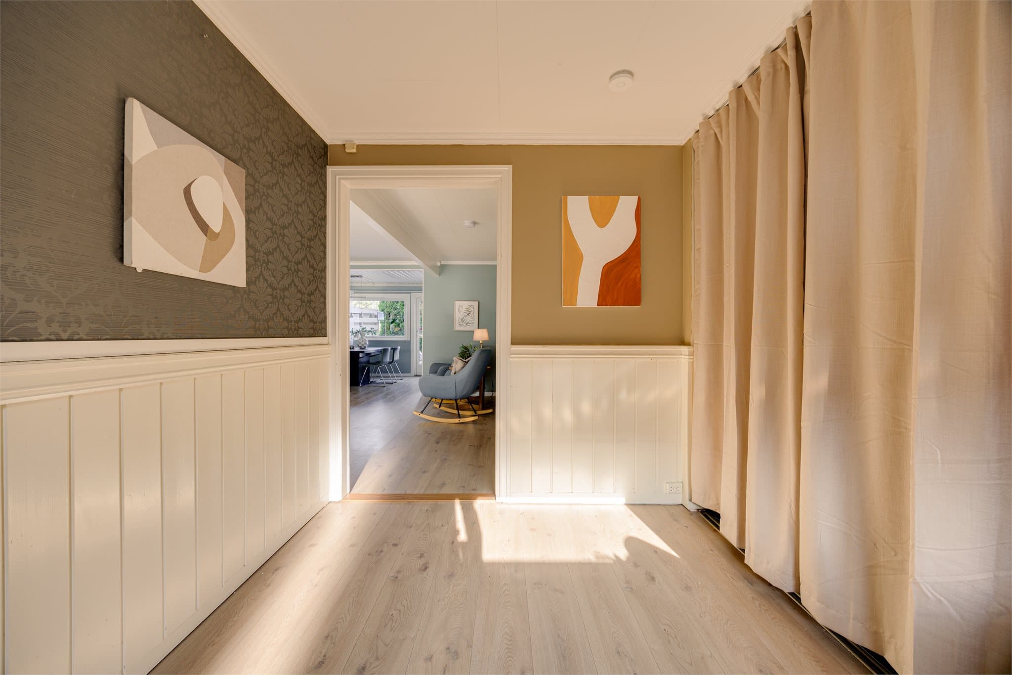 Boligen ønsker deg velkommen med en romslig og innbydende entré med gode garderobeløsninger. Her er det rikelig med plass til yttertøy og sko, og sonen oppleves både praktisk og visuelt pent når du får skjult rotet bak gardiner.