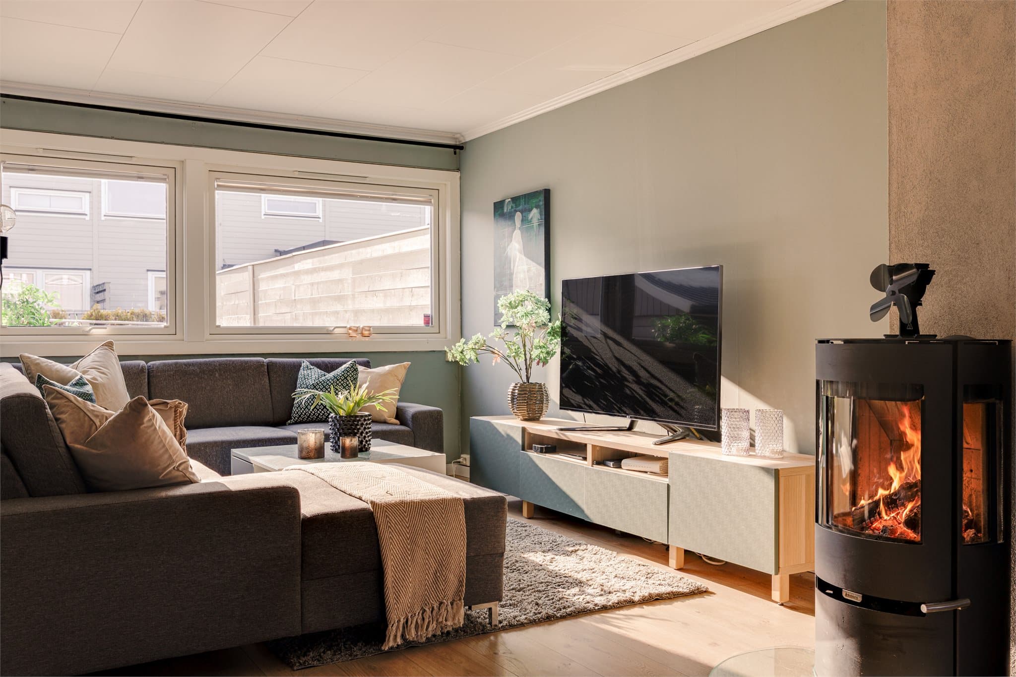 Peisen som er plassert midt i rommet tilfører både varme og atmosfære, samt skaper en lun ramme rundt oppholdsrommet.