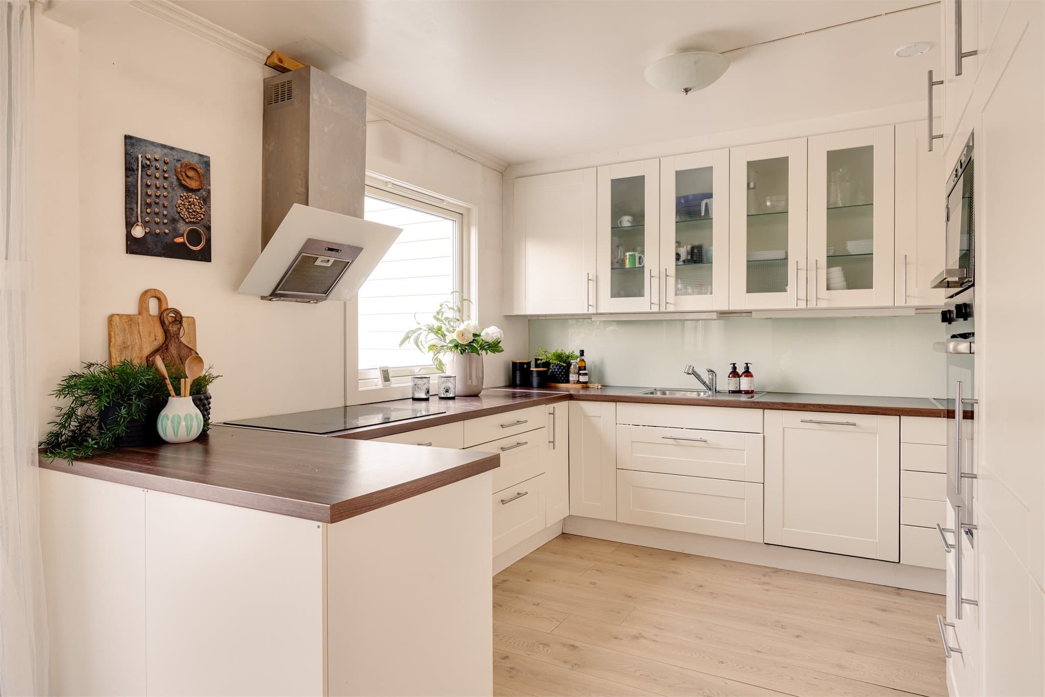 Kjøkkenet har en klassisk og tidløs innredning med profilerte fronter, supplert med enkelte overskap med glassfronter som gir et elegant uttrykk.