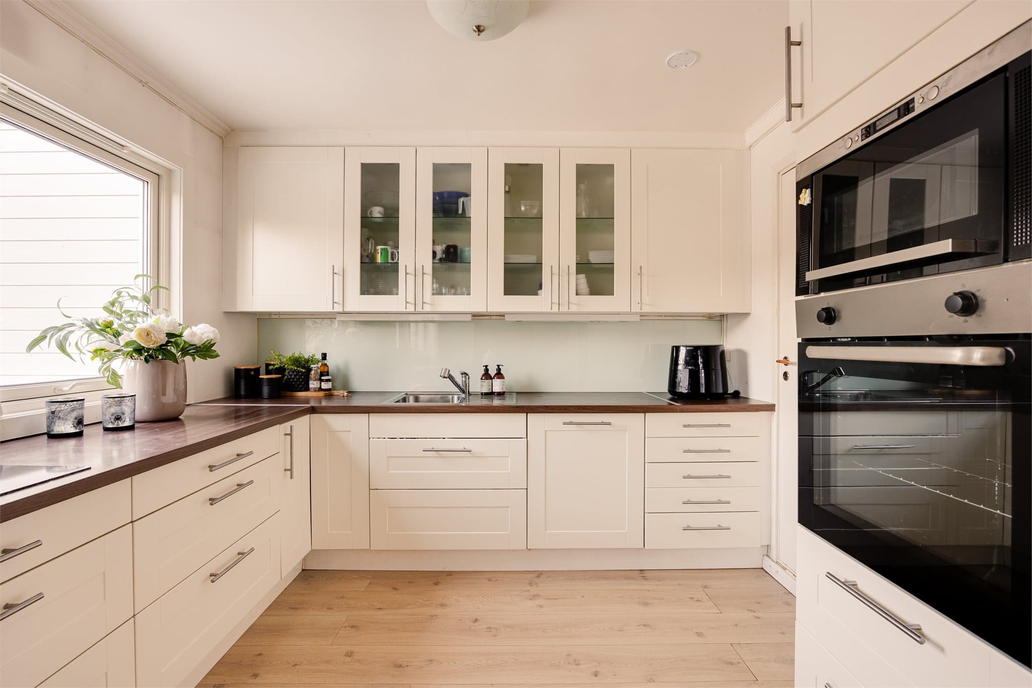 Laminat benkeplate med nedfelt kum i rustfritt stål gir en robust og funksjonell arbeidsflate.