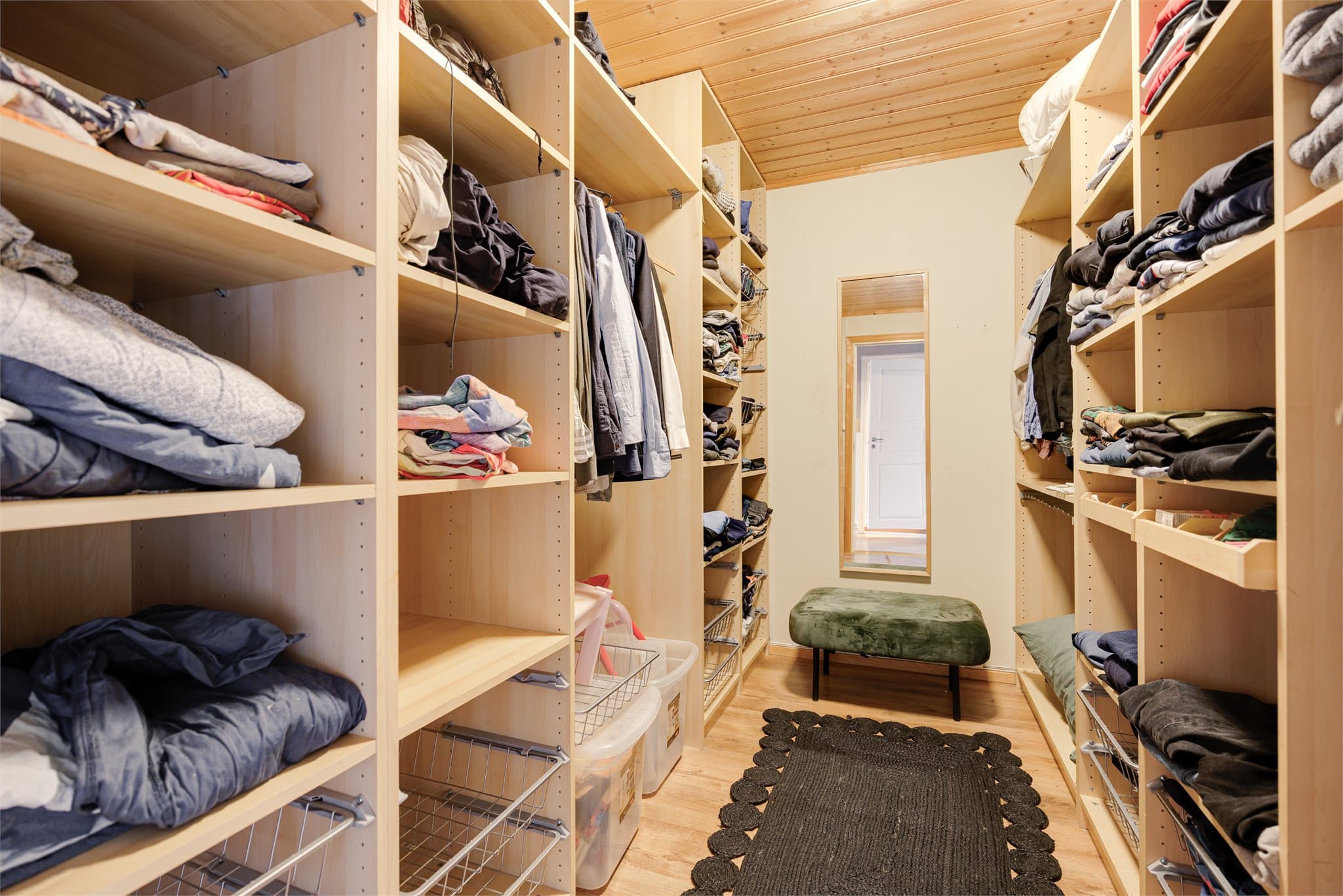 Praktisk og romslig walk-in garderobe med garderobeinnredning på begge sider. Her er det god oppbevaringsplass for klær, sko og tekstiler – en løsning som bidrar til en ryddig og harmonisk hverdag.