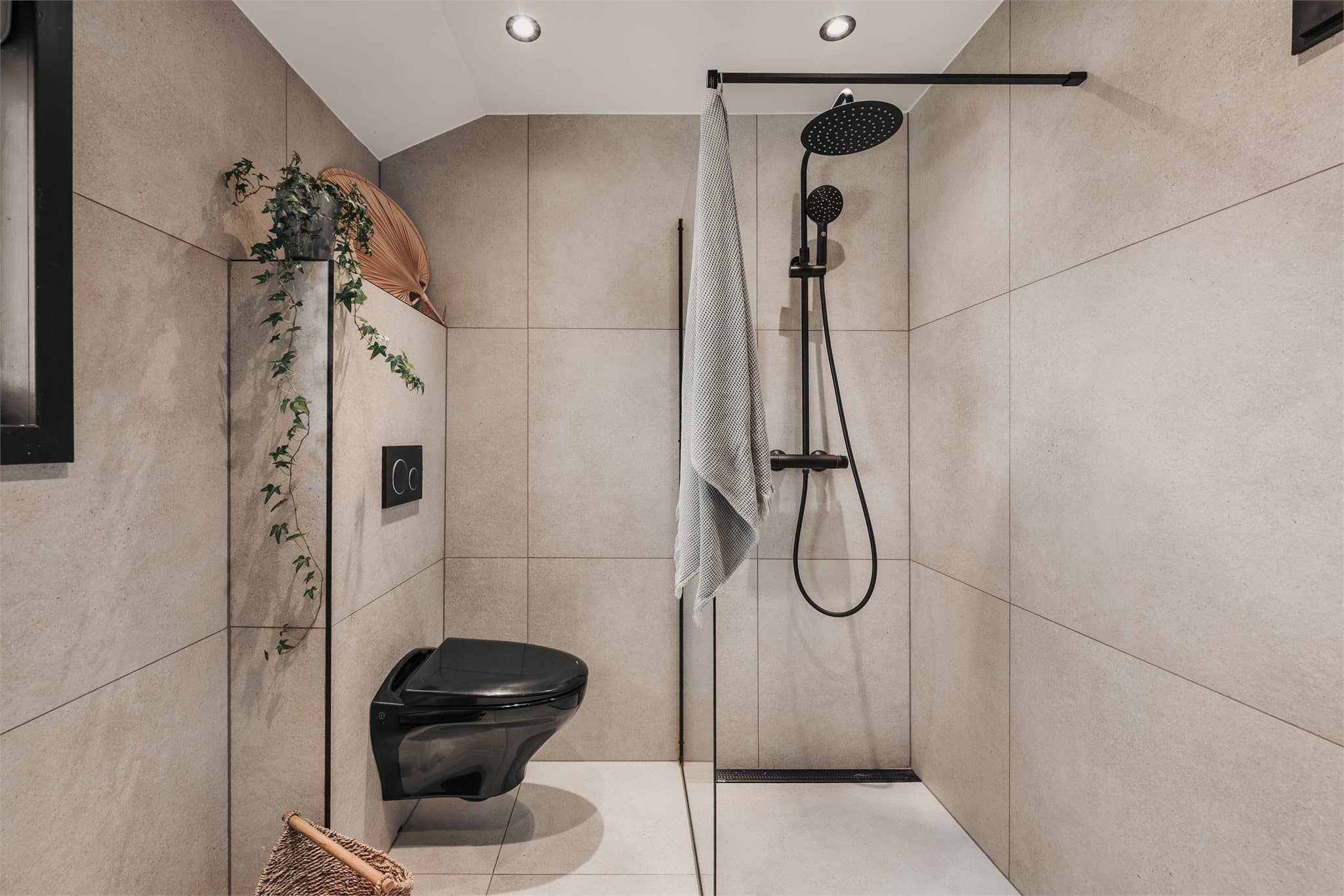 Badet er flislagt og har varmekabler i gulv. Innredningen består av servantskap med glatte fronter, benkeplate og servantbolle, samt speil med integrert belysning montert over servant.